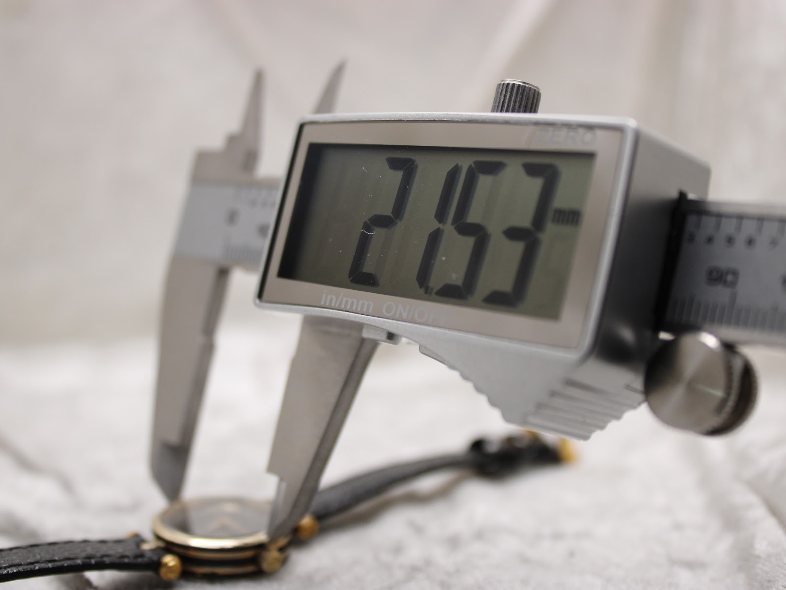 Digital caliper measuring the case diameter of the Gucci 2000L, displaying a precise measurement of 21.53 mm.