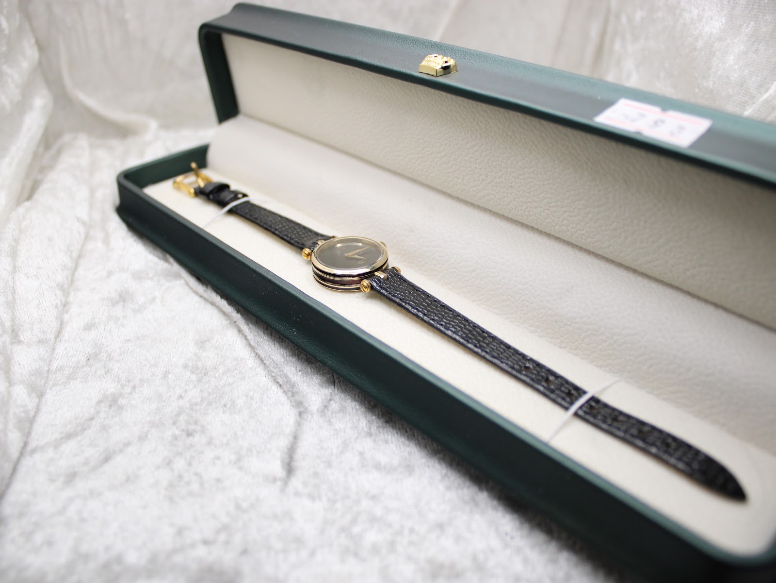Overhead view of the Gucci 2000L watch presented in a green hinged display box.