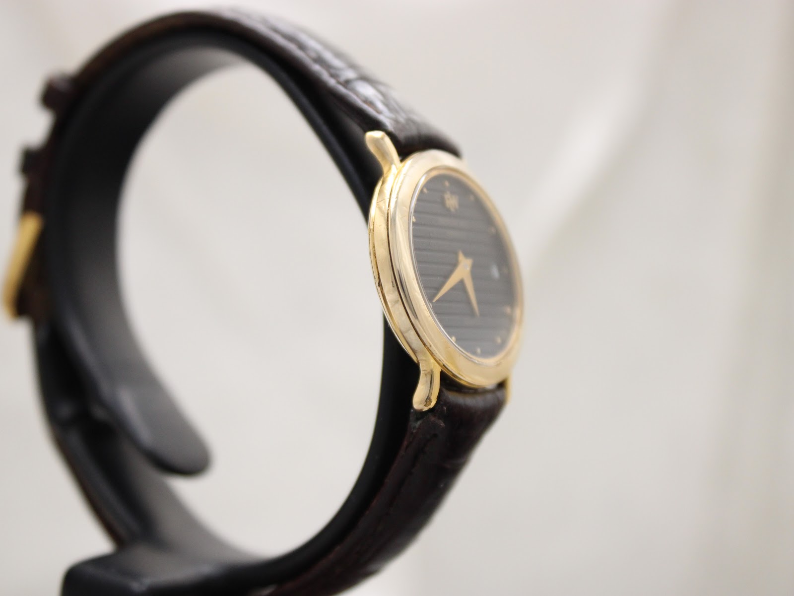 Another side view of the Raymond Weil watch, highlighting the slender case profile and the textured black leather strap.