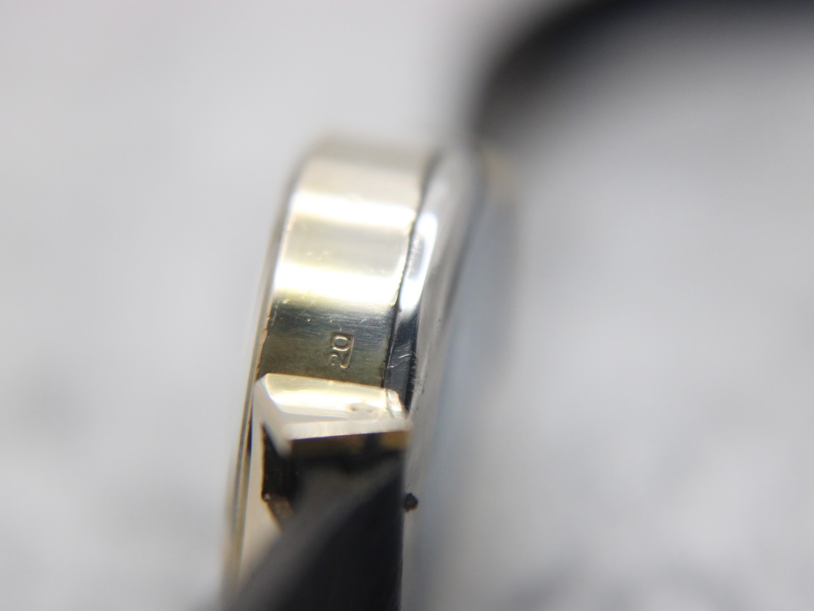 Close-up side view of the gold plated watch case, showing the "20" micron plating mark.