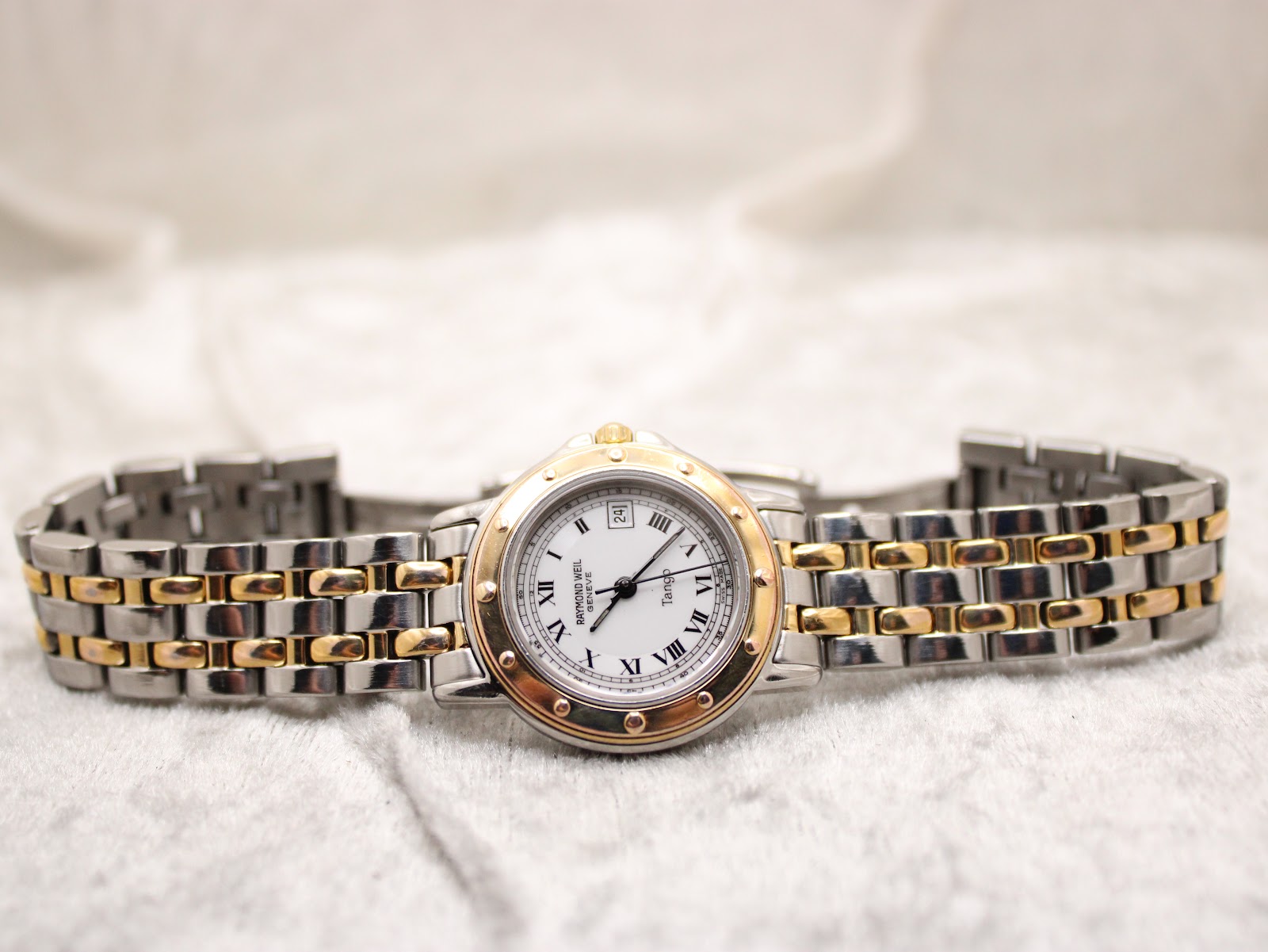 Overhead view of the Raymond Weil Tango watch with its two-tone bracelet extended flat, emphasising the overall design.