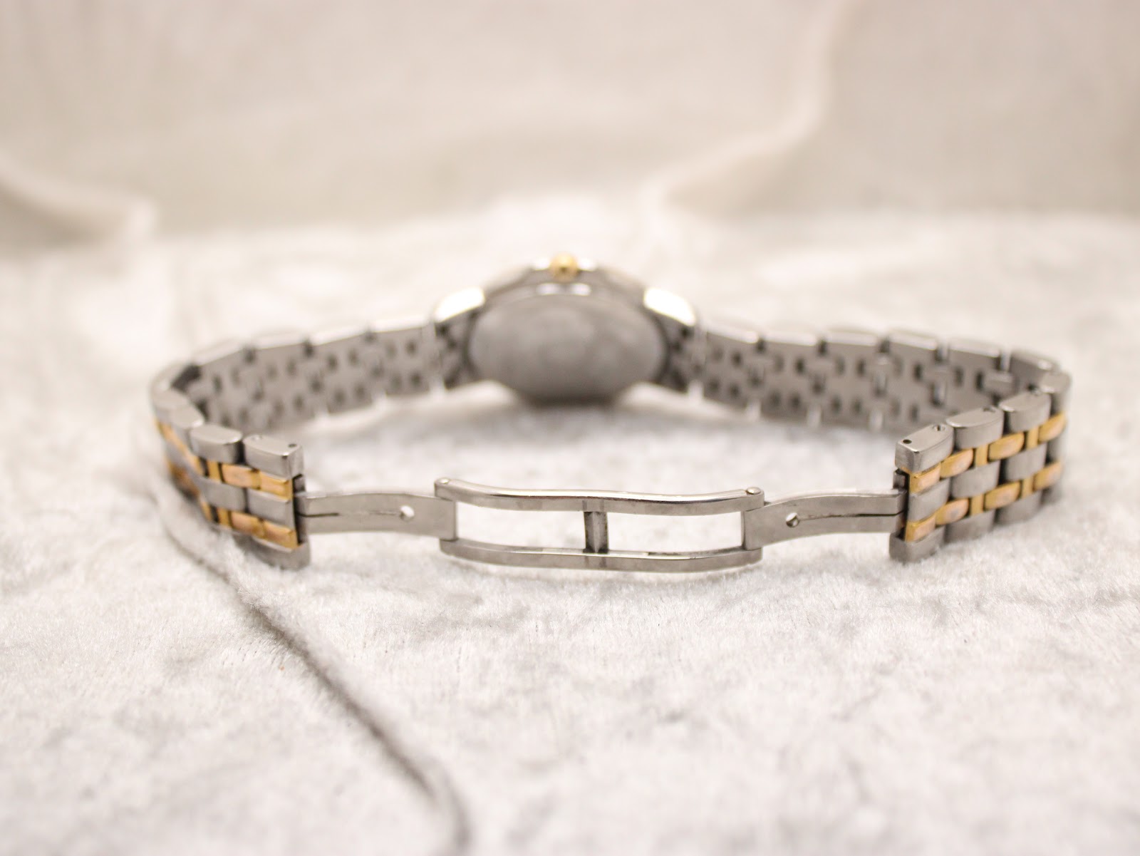 Rear close-up view of the open two-tone stainless steel bracelet clasp, showing its construction.