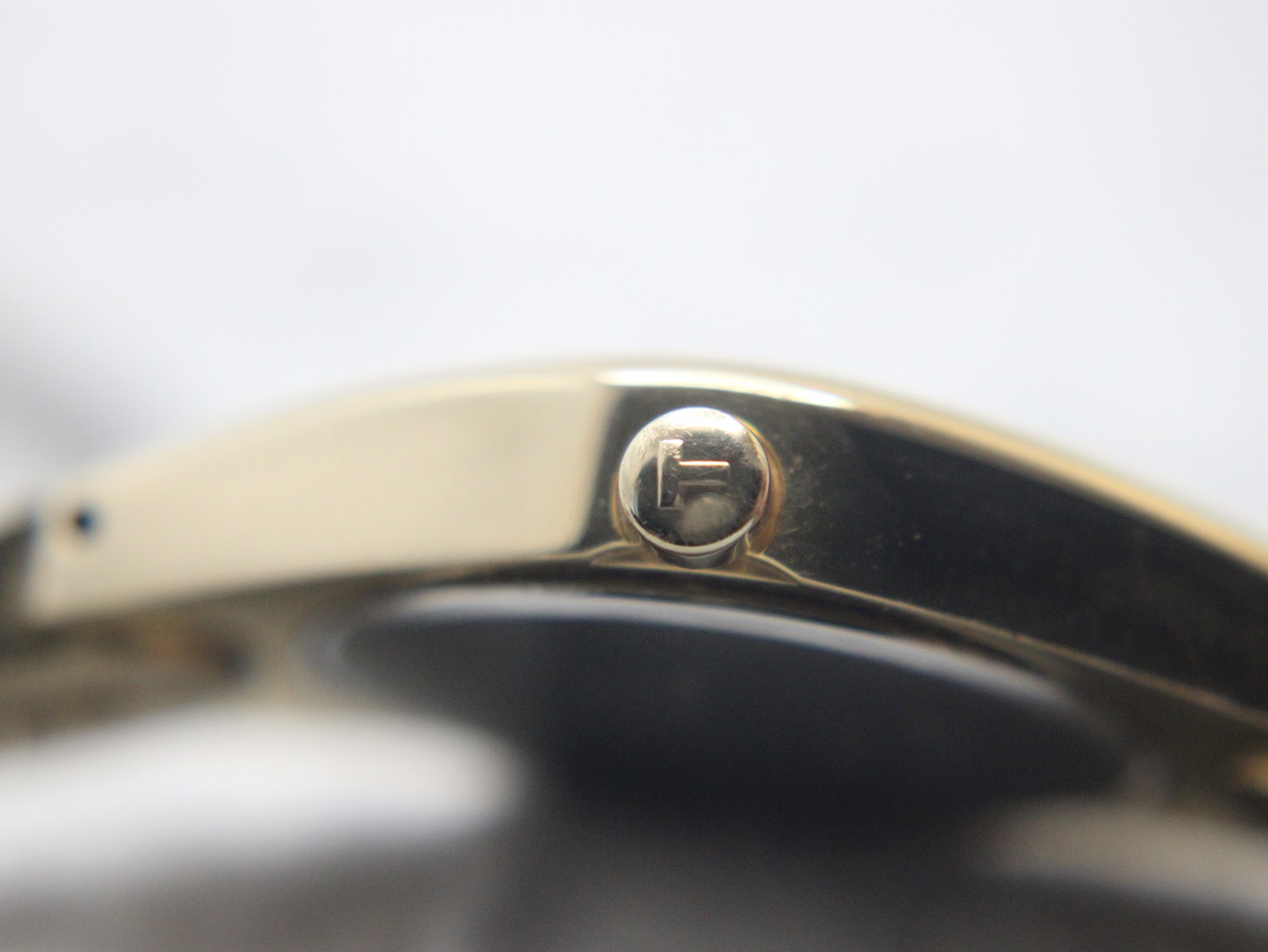 Extreme close-up of the original signed Tissot crown, clearly showing the 'T' logo.