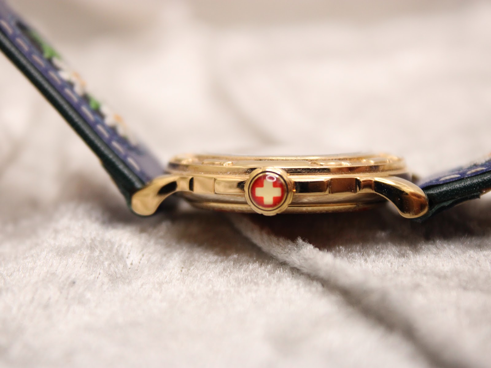 Profile view of the Michel Jordi Genève watch and strap, highlighting the case thickness and Swiss cross crown.
