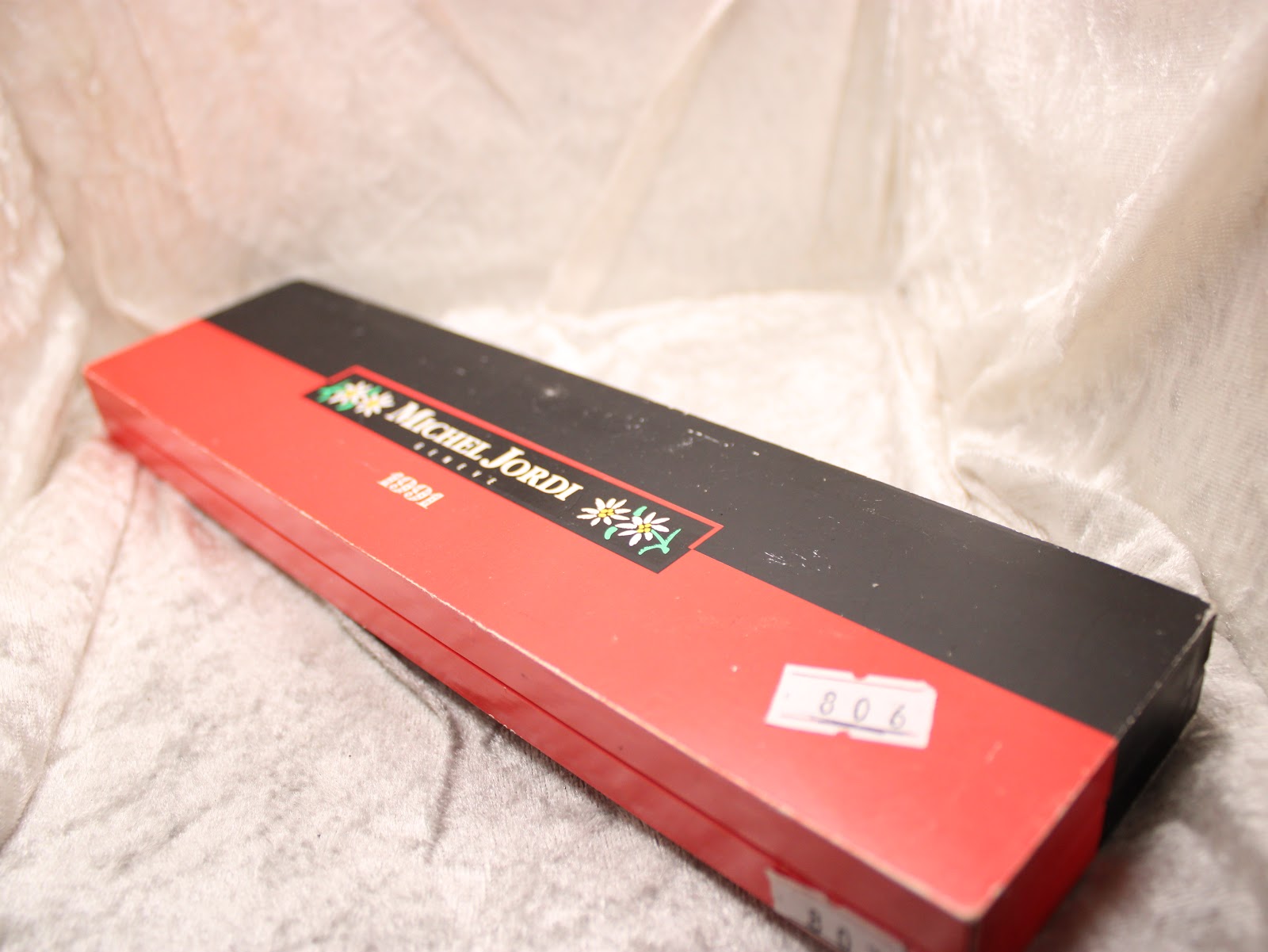 Top view of the closed Michel Jordi Genève watch presentation box, showing "Michel Jordi Geneve 1991" and a sticker with "806".