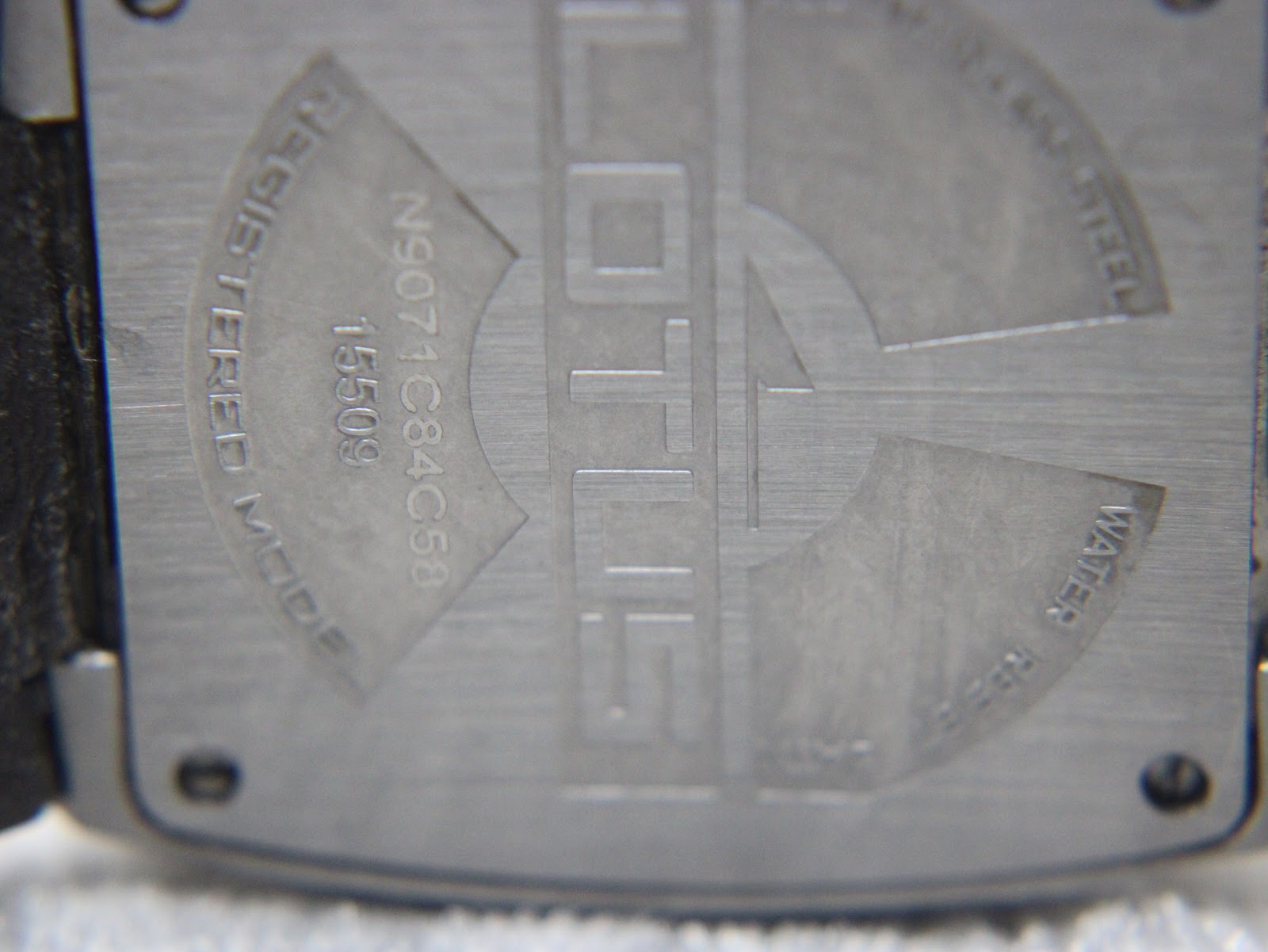 Close-up of the brushed stainless steel case back of the Lotus 15509, showing engraved details including "LOTUS", "REGISTERED MODEL", "15509", serial number "N9071C84C58", and "WATER RESIST".
