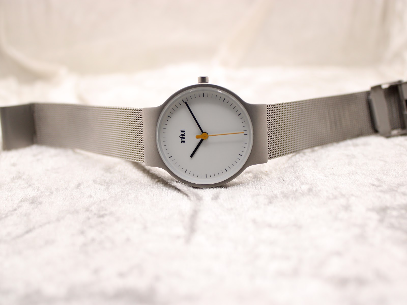 Full view of the Braun BN0211 watch laid flat, displaying the white dial, matte grey case, and the extended stainless steel mesh bracelet.