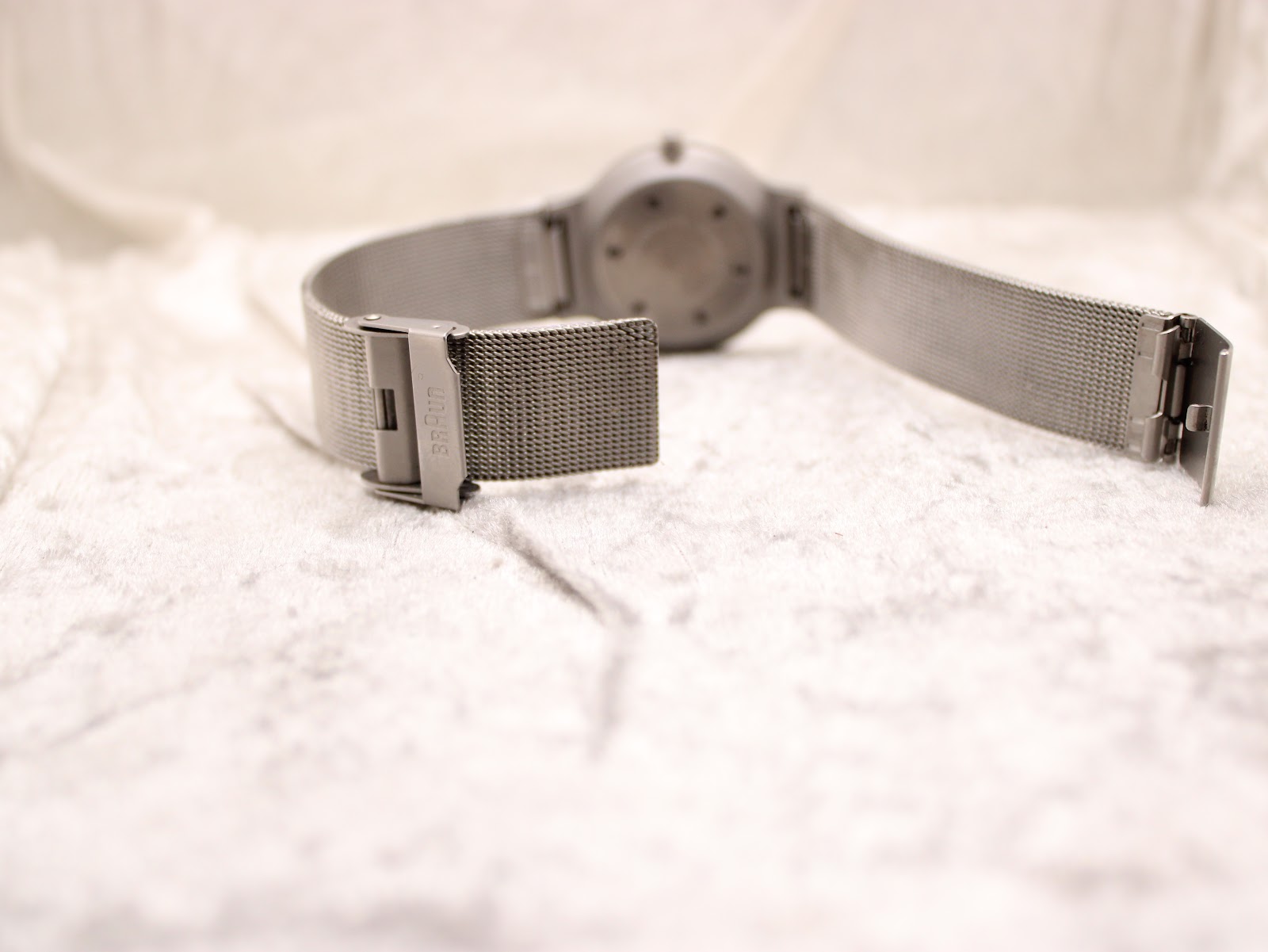 Close-up of the adjustable stainless steel mesh clasp of the Braun BN0211 watch, with the 'BRAUN' logo clearly visible.
