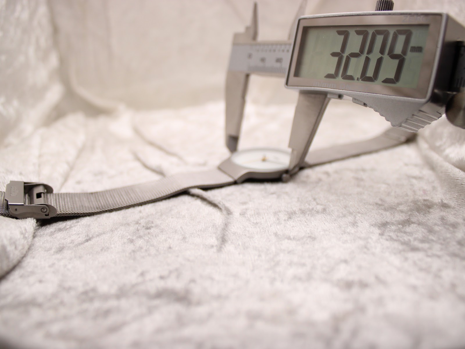 A digital caliper measuring the case diameter of the Braun BN0211 watch, displaying a precise measurement of 32.09 mm.