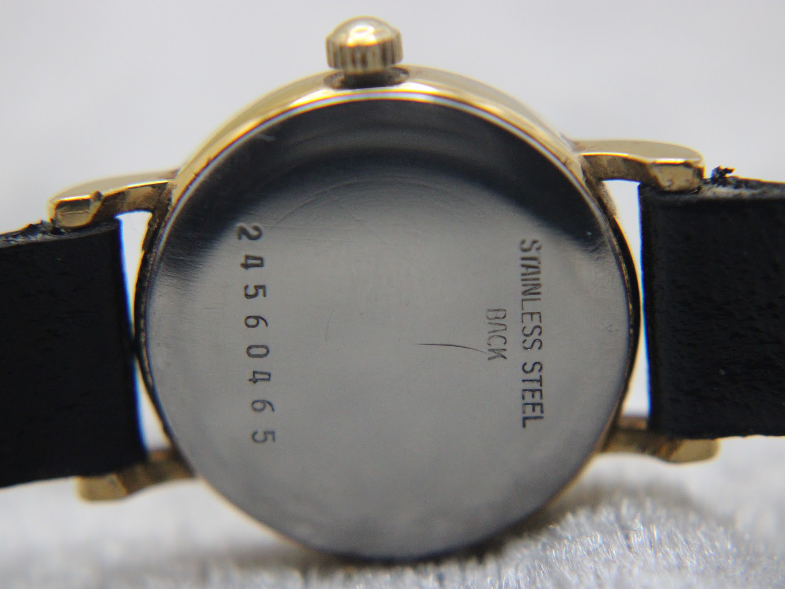 Close-up of the stainless steel case back of the Longines Présence watch, engraved with the serial number "24560465".