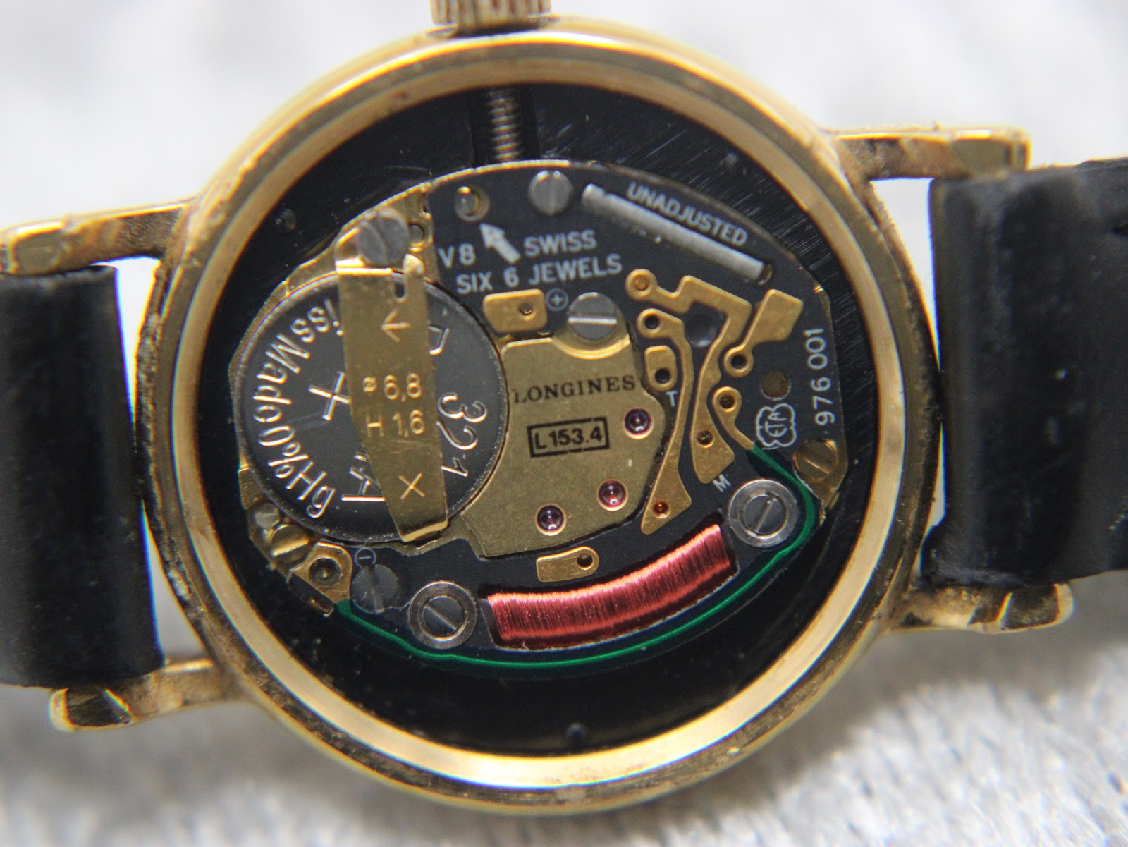 Macro shot of the Longines L153.4 Swiss quartz movement with six jewels, showing the battery compartment and internal components.