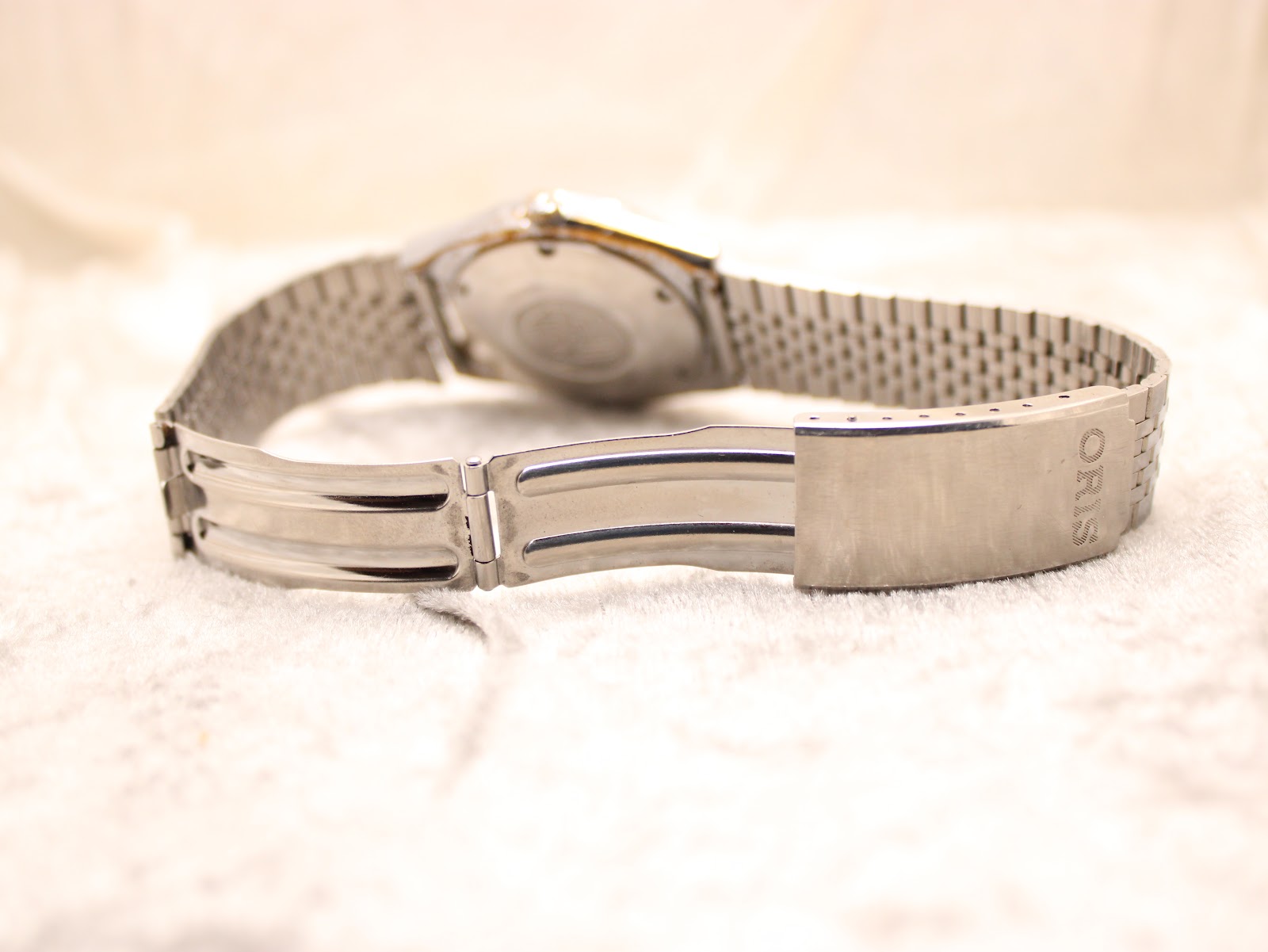 Underside view of the watch's integrated stainless steel bracelet and its fold-over clasp.