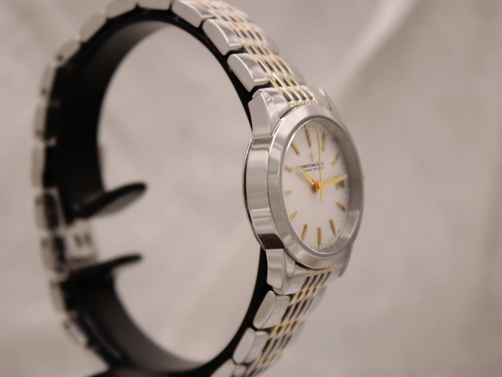 Angled side view of the Dreyfuss & Co watch, highlighting the two-tone bracelet and case on a display stand.