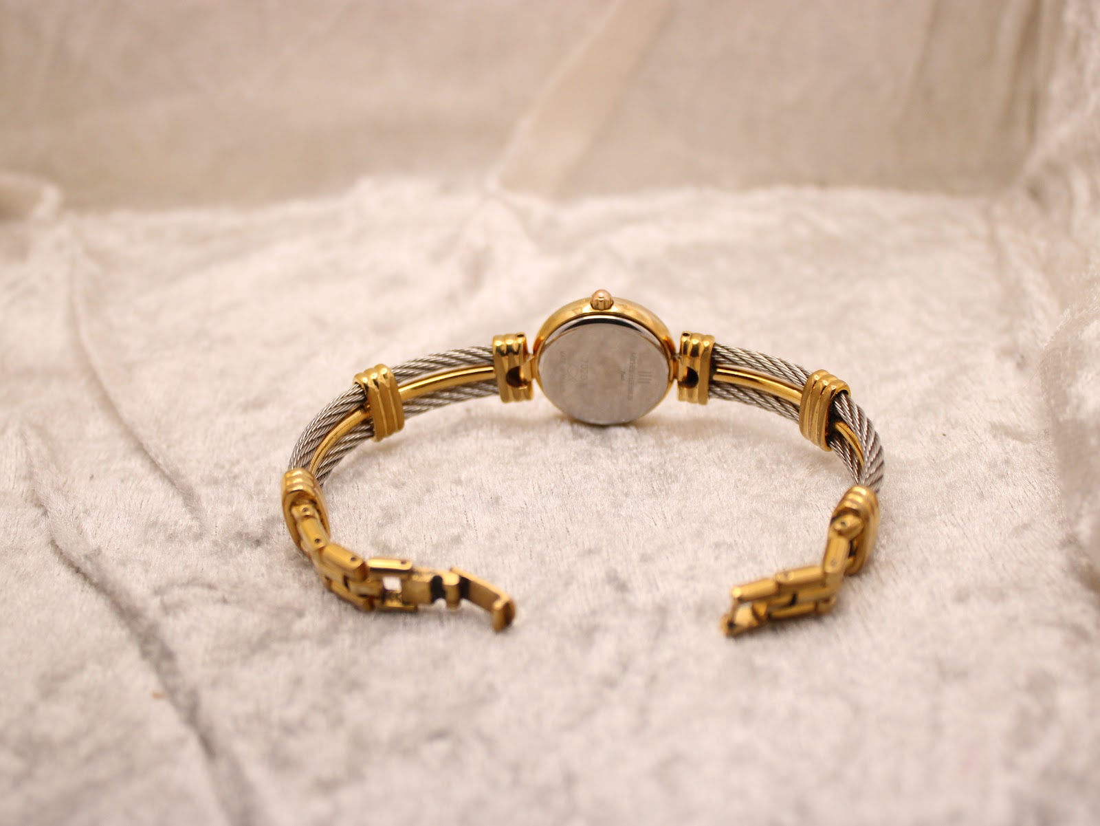 Rear view of the Michel Herbelin watch with its two-tone cable bracelet laid flat, showing the case back and open clasp.