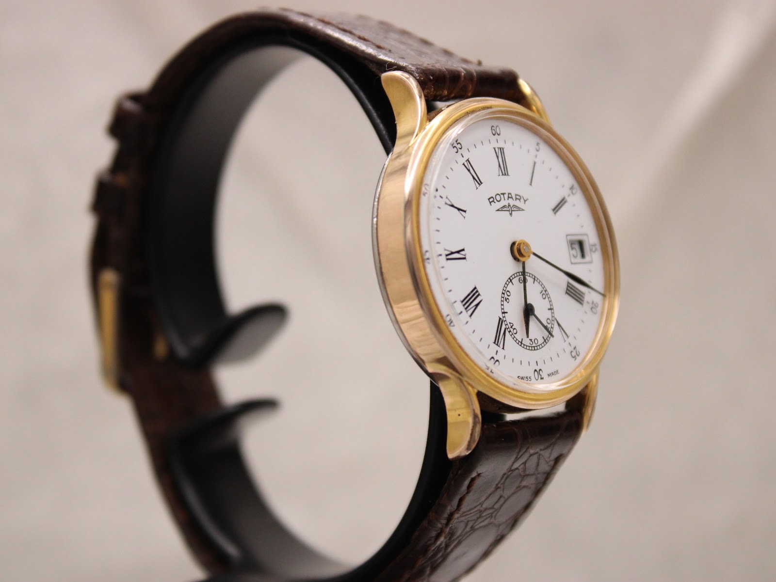 Another side angle of the Rotary watch on a display stand, highlighting the curved lugs and case thickness.