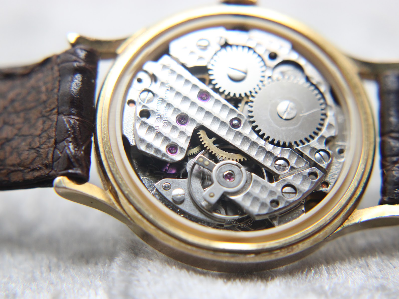 Close-up view of the intricate mechanical hand-wind movement inside the Rotary watch case.