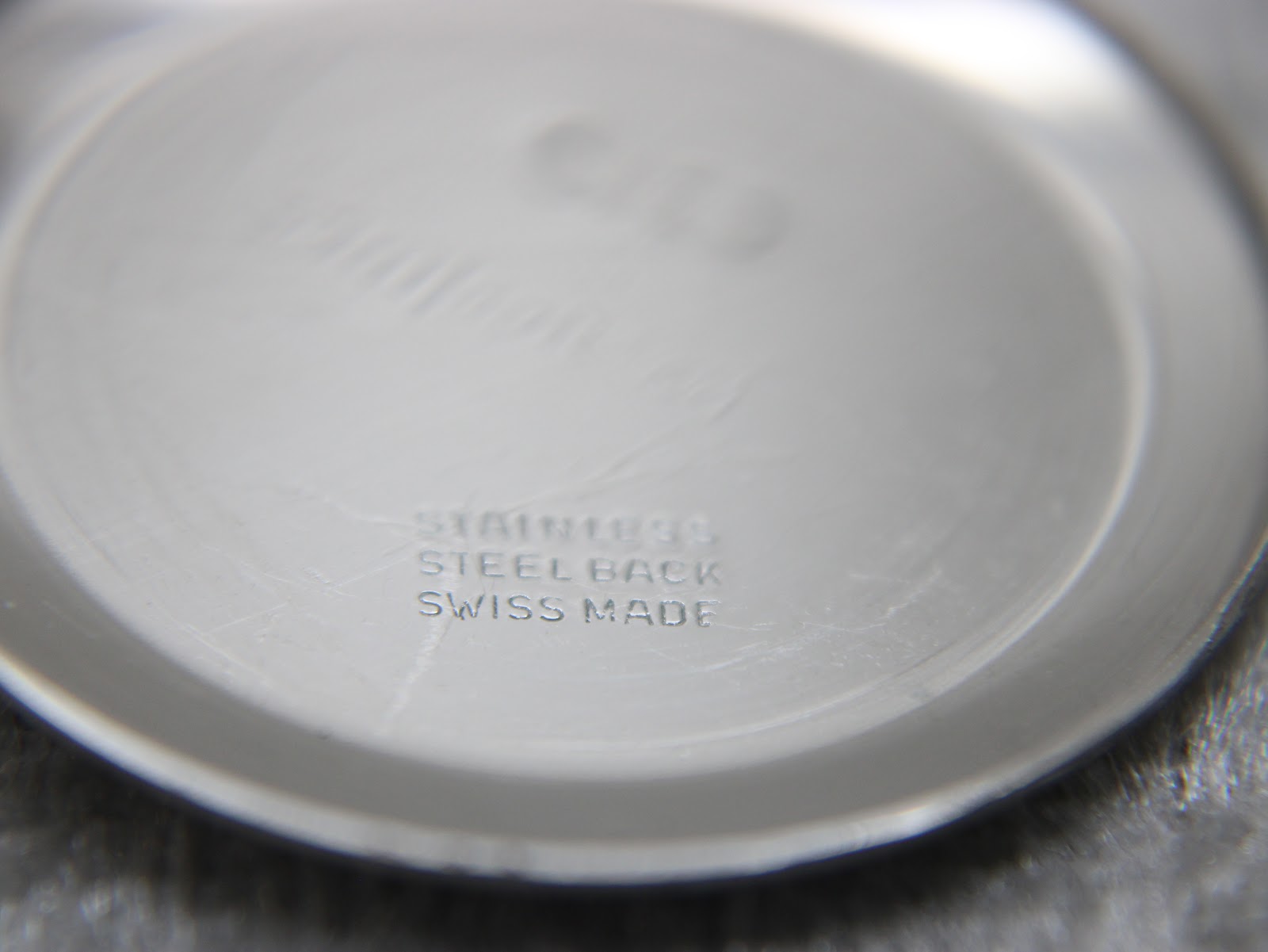 Interior of the watch case back, clearly showing "stainless steel back swiss made" engraving.