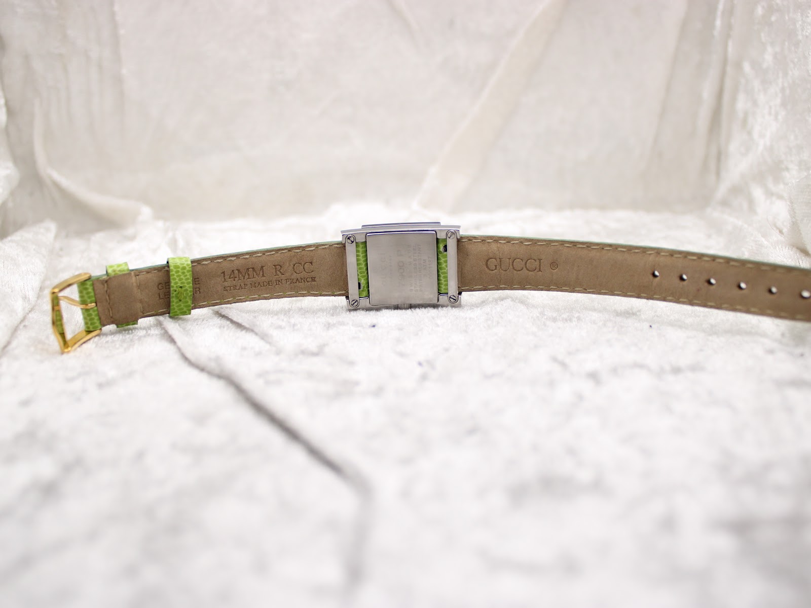 Underside view of the green leather strap, showing "14MM R.C.C STRAP MADE IN FRANCE" and "GUCCI" embossed markings.