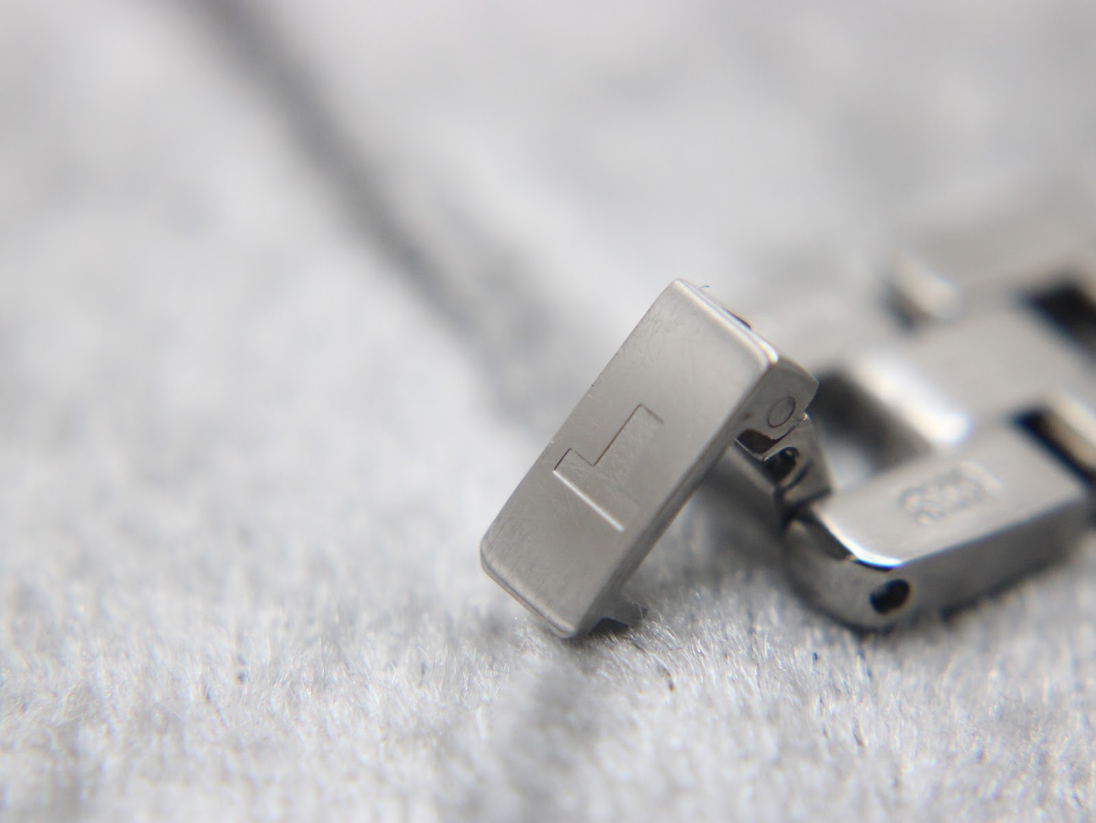 Close-up of the Tissot signed folding clasp on the stainless steel bracelet.