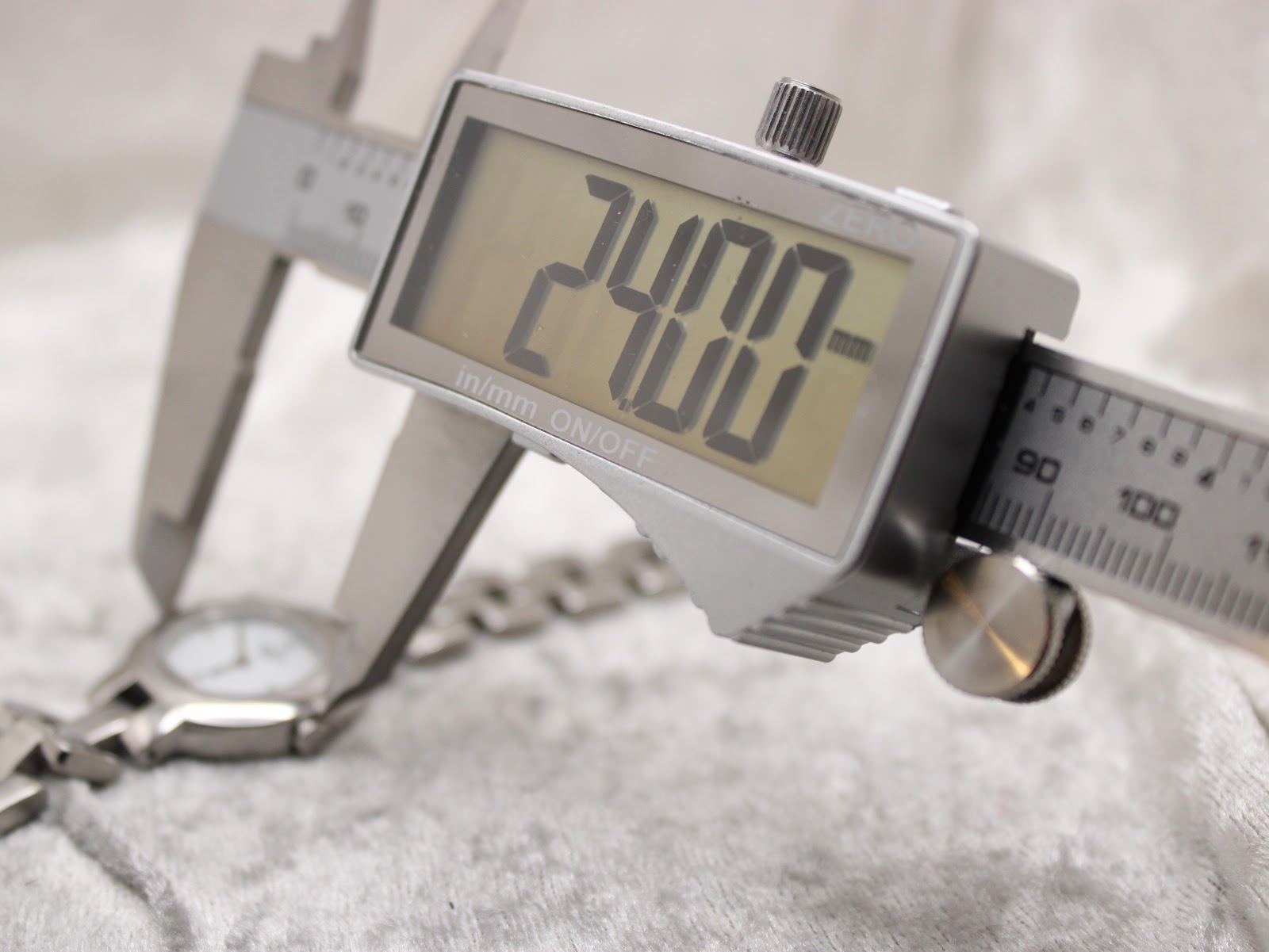 Digital caliper measuring the watch case diameter at precisely 24.00mm.