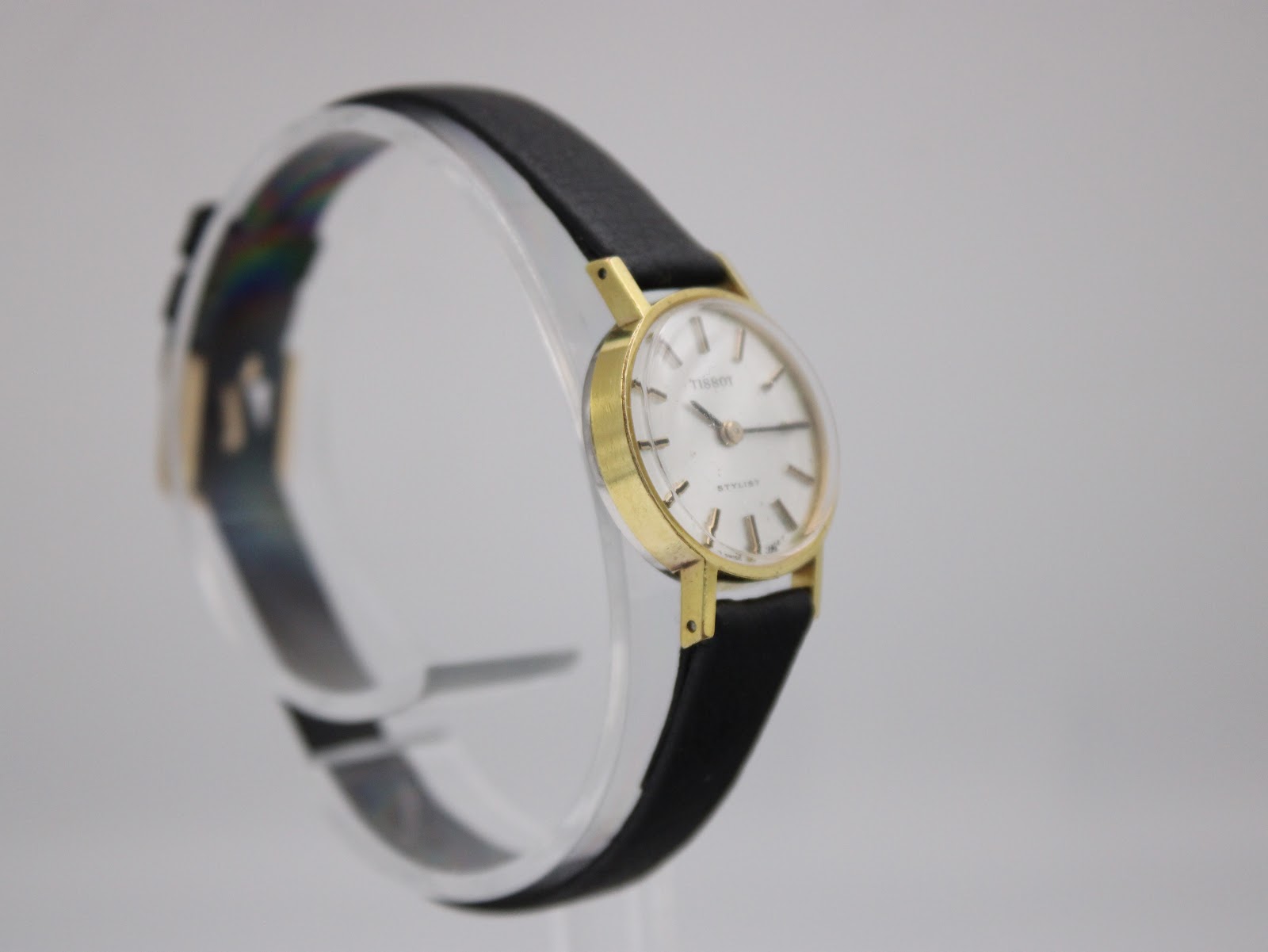 Another angled side view of the Tissot Stylist watch, highlighting the case profile and strap attachment.
