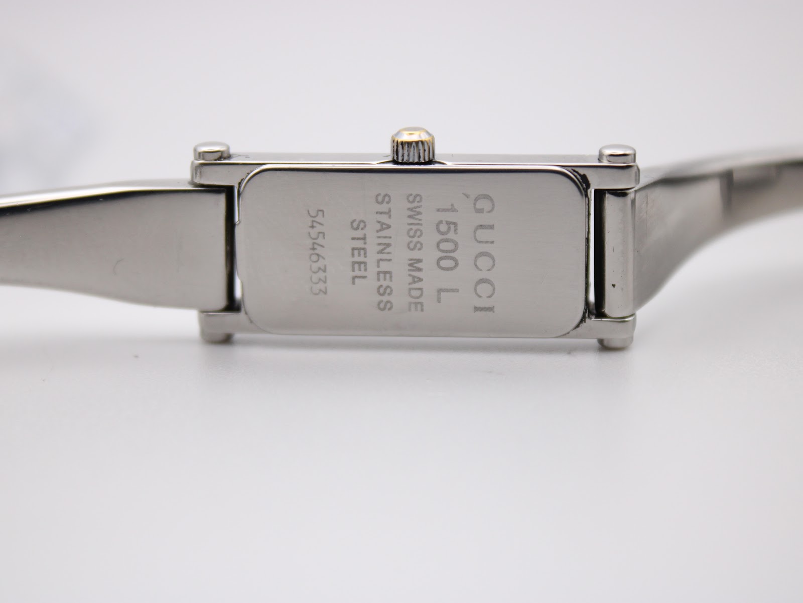 Case back of Gucci 1500L showing "Gucci 1500 L Swiss Made Stainless Steel" and serial number.