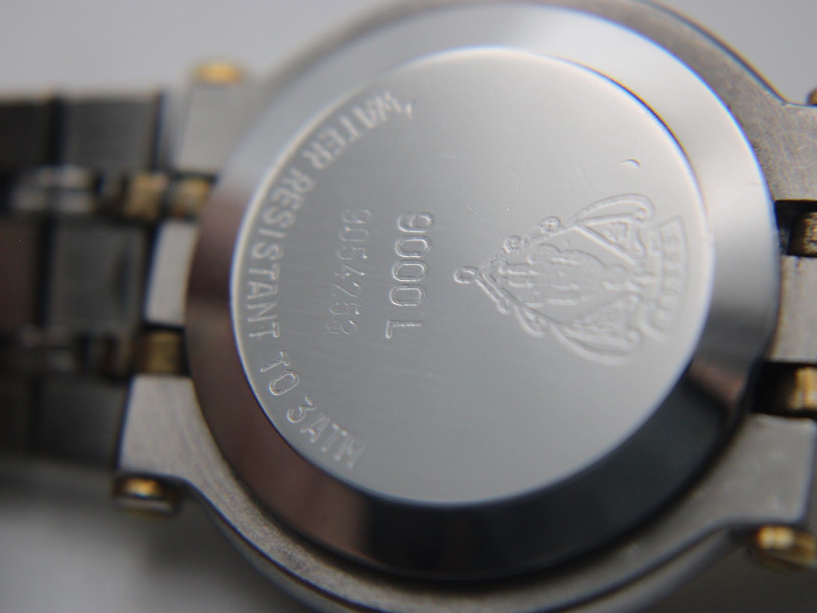 Close-up of the stainless steel case back of the Gucci 9000 L, showing 'Gucci', '9000 L', serial number '9054253', and 'Water Resistant to 3ATM' engravings.