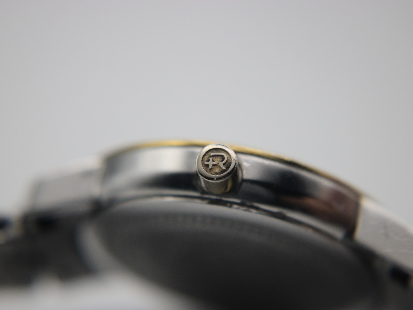 Close-up of the original Roamer signed crown, clearly showing the embossed 'R' logo.