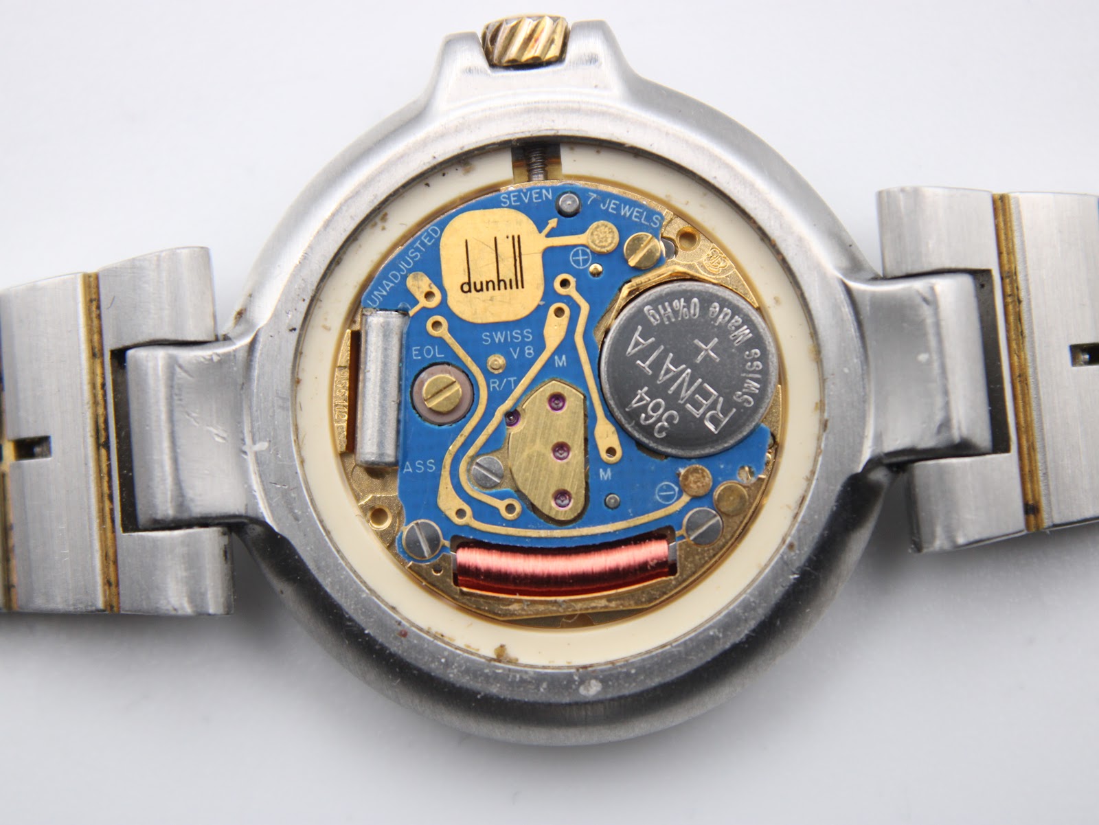 Close-up of the opened case back revealing the Dunhill-signed ETA 976.001 quartz movement and Renata battery.