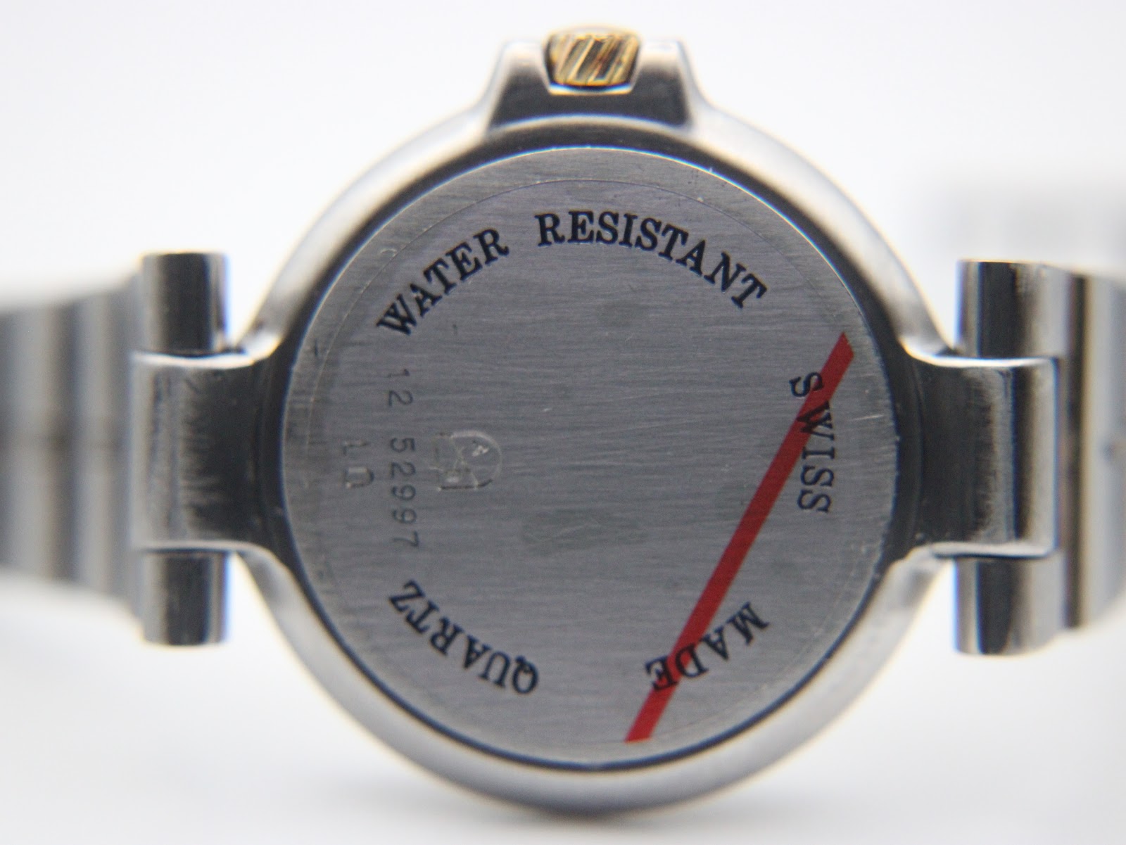 Close-up of the brushed stainless steel case back with "Water Resistant", "Swiss Made", "Quartz", and serial number engraving.