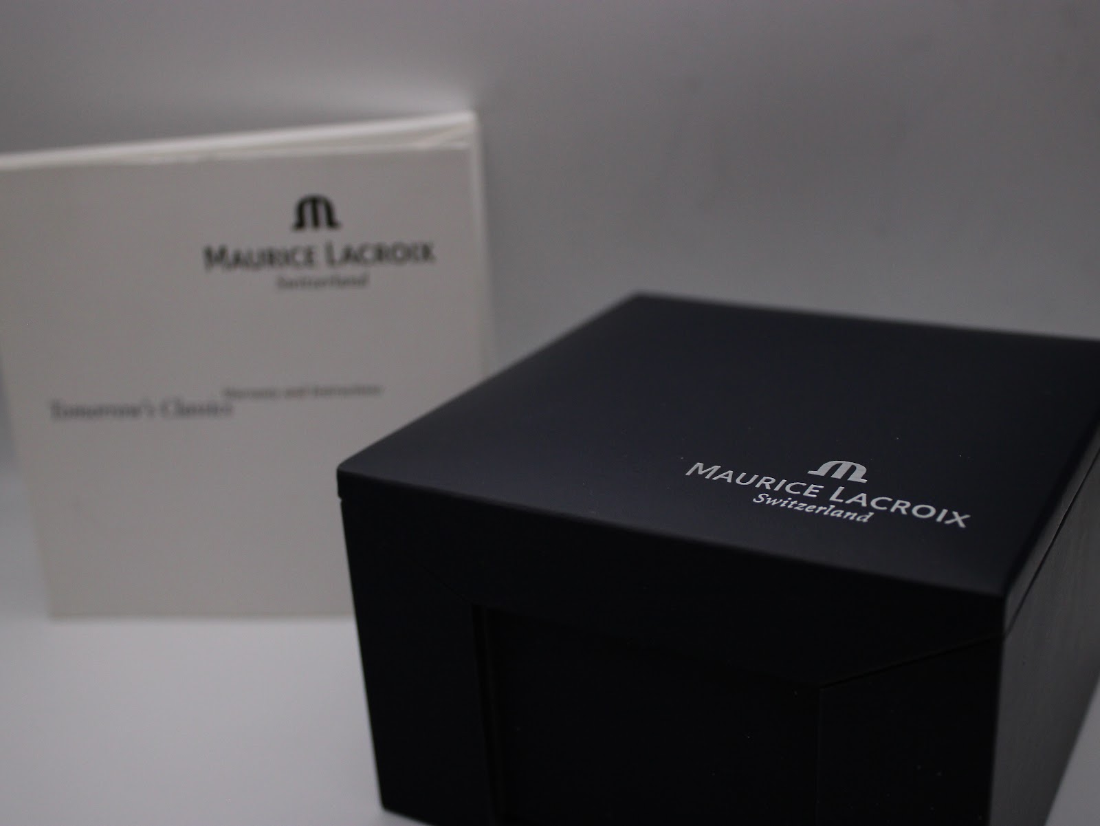 The original black Maurice Lacroix presentation box and white outer sleeve with branding.