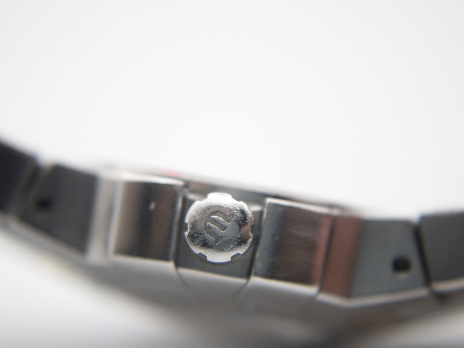 Close-up of the crown, featuring the distinctive Maurice Lacroix 'M' logo, on the side of the watch case.