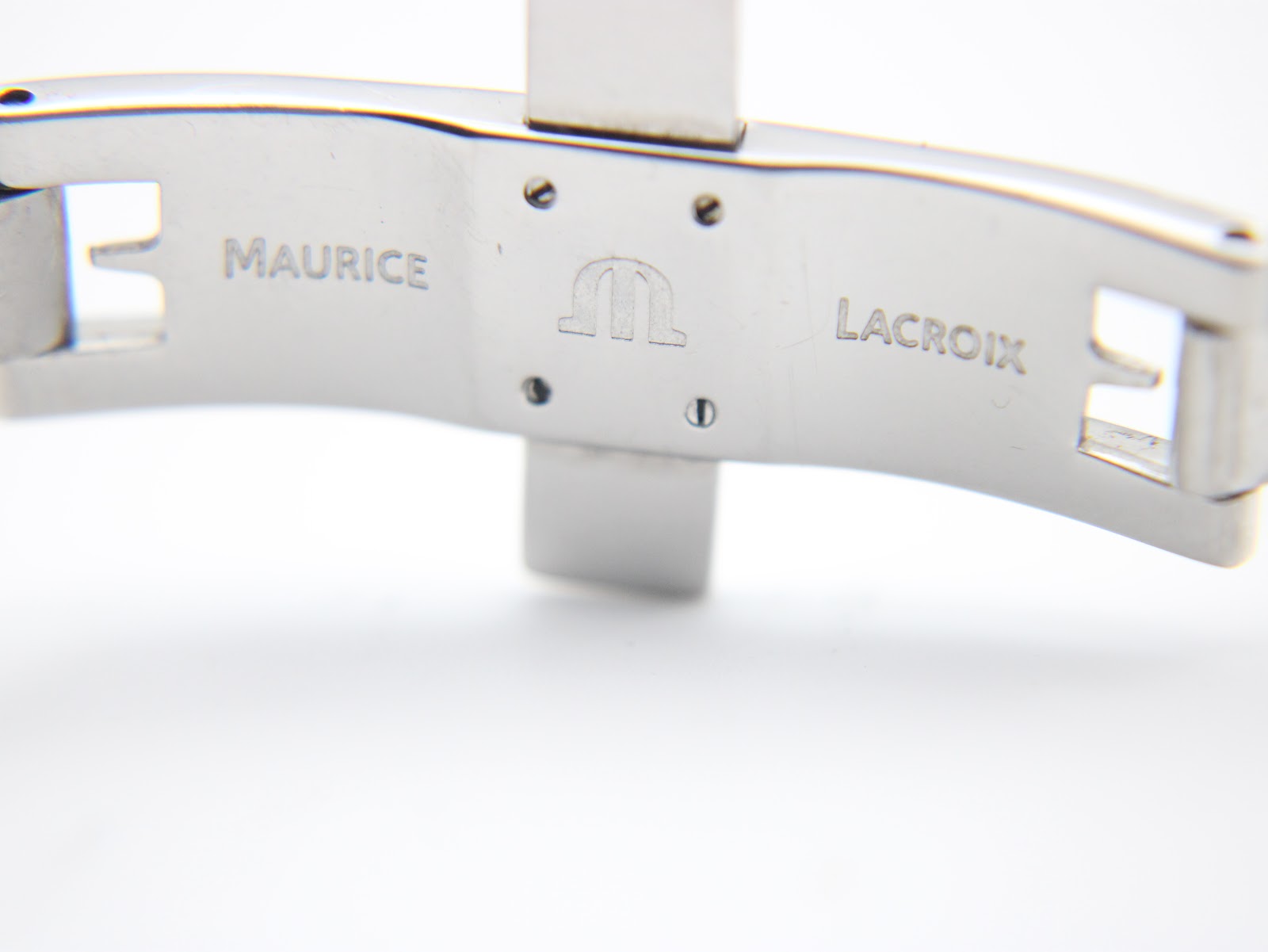Close-up of the polished stainless steel deployment clasp, engraved with 'Maurice Lacroix'.