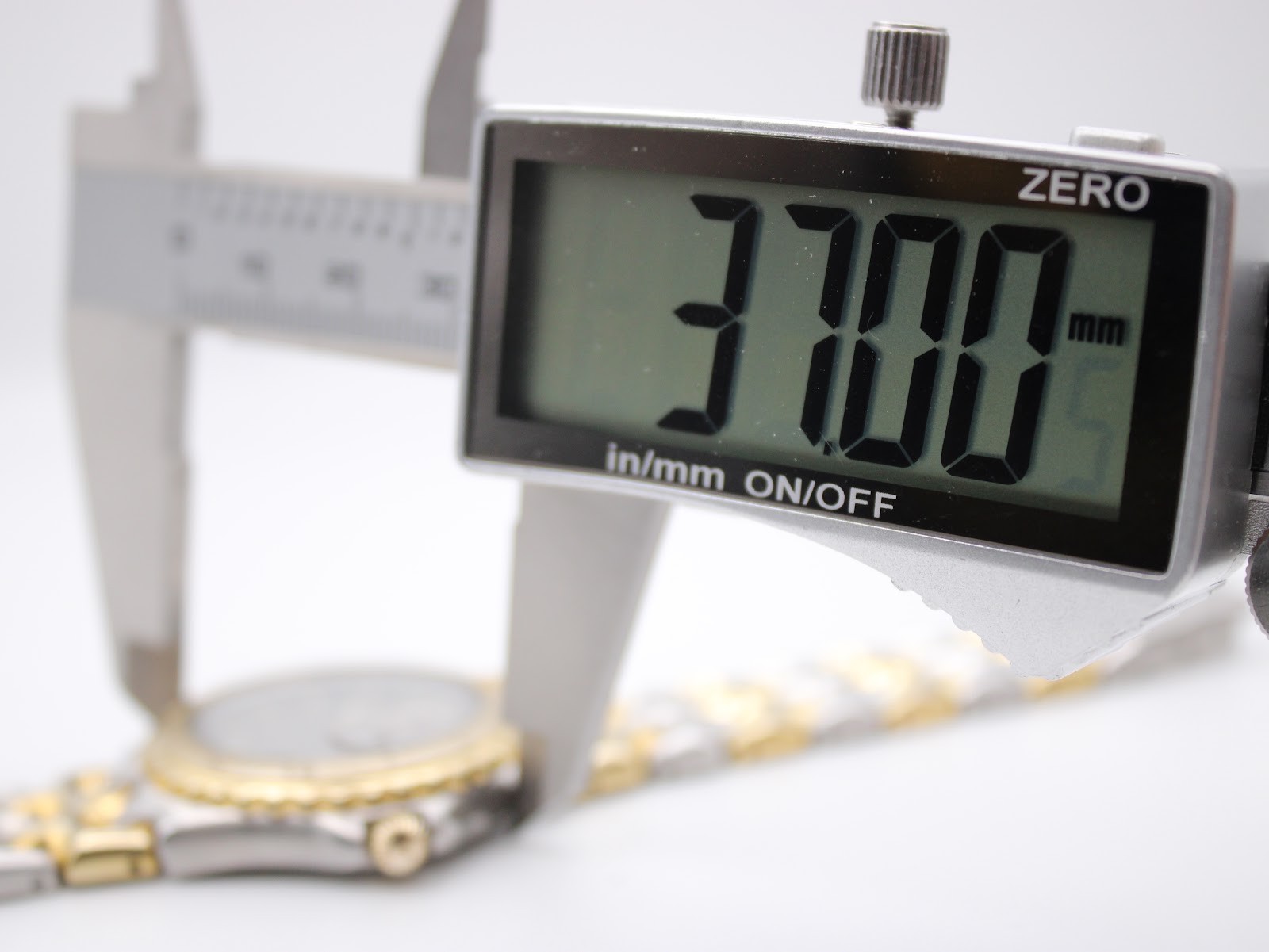 Close-up of a digital caliper measuring the watch case diameter at 37.00mm.