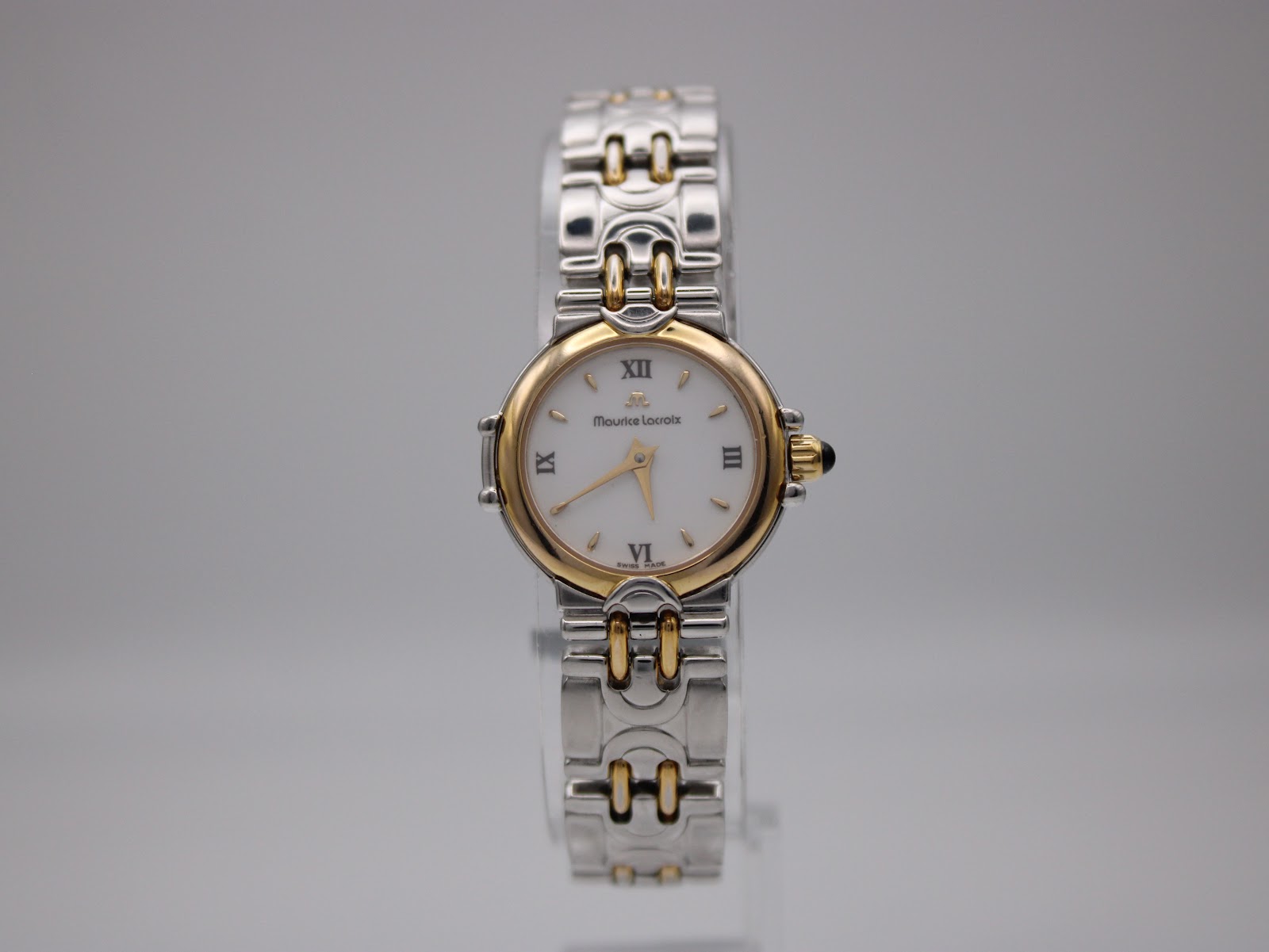 Frontal view of the Maurice Lacroix ladies watch, showing the white dial with Roman numerals and gold-plated bezel.
