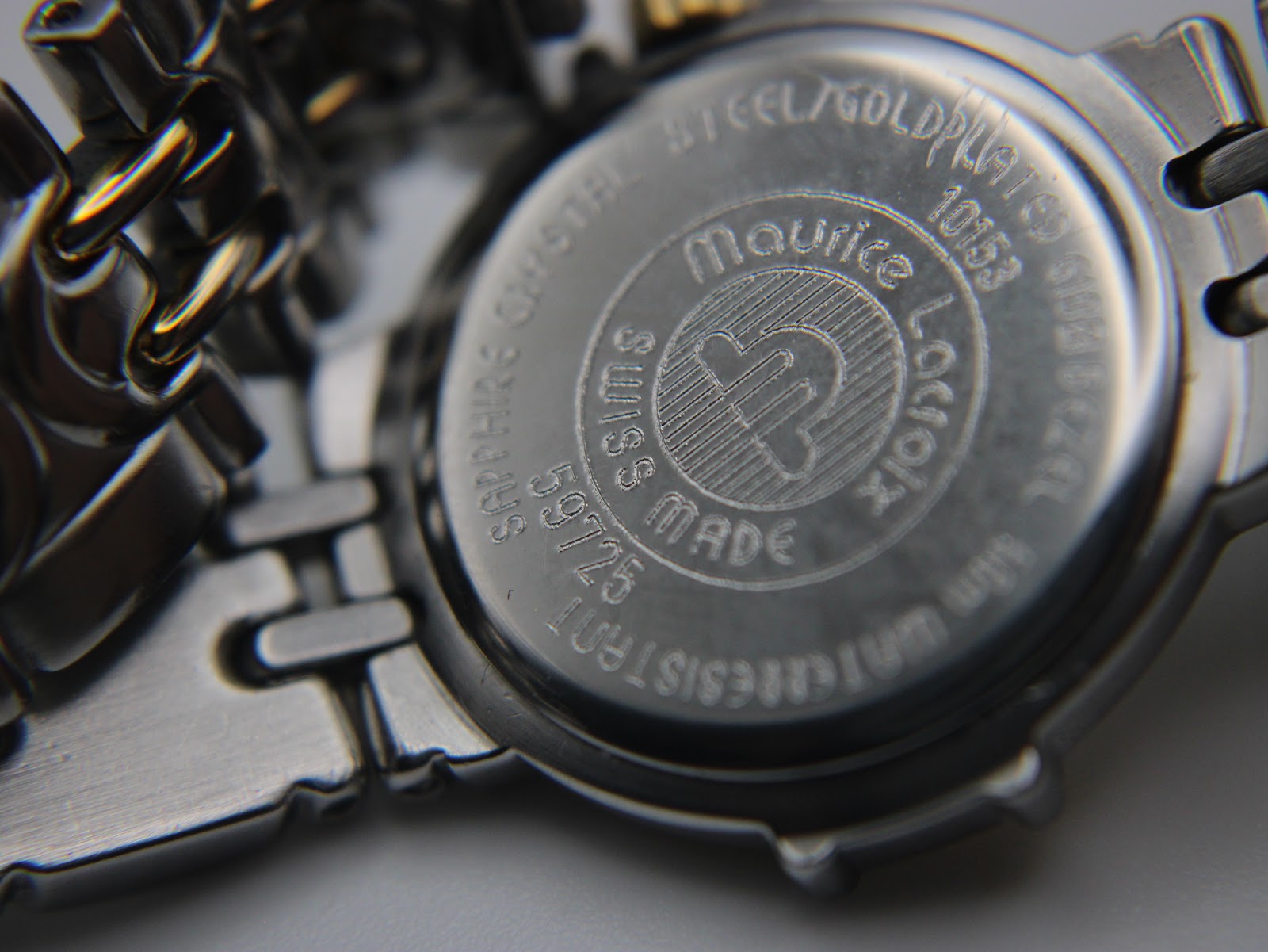 Close-up of the watch's stainless steel case back, engraved with 'Maurice Lacroix', 'Swiss Made', 'Sapphire Crystal', '10 Bar Water Resistant', and reference number 59725.