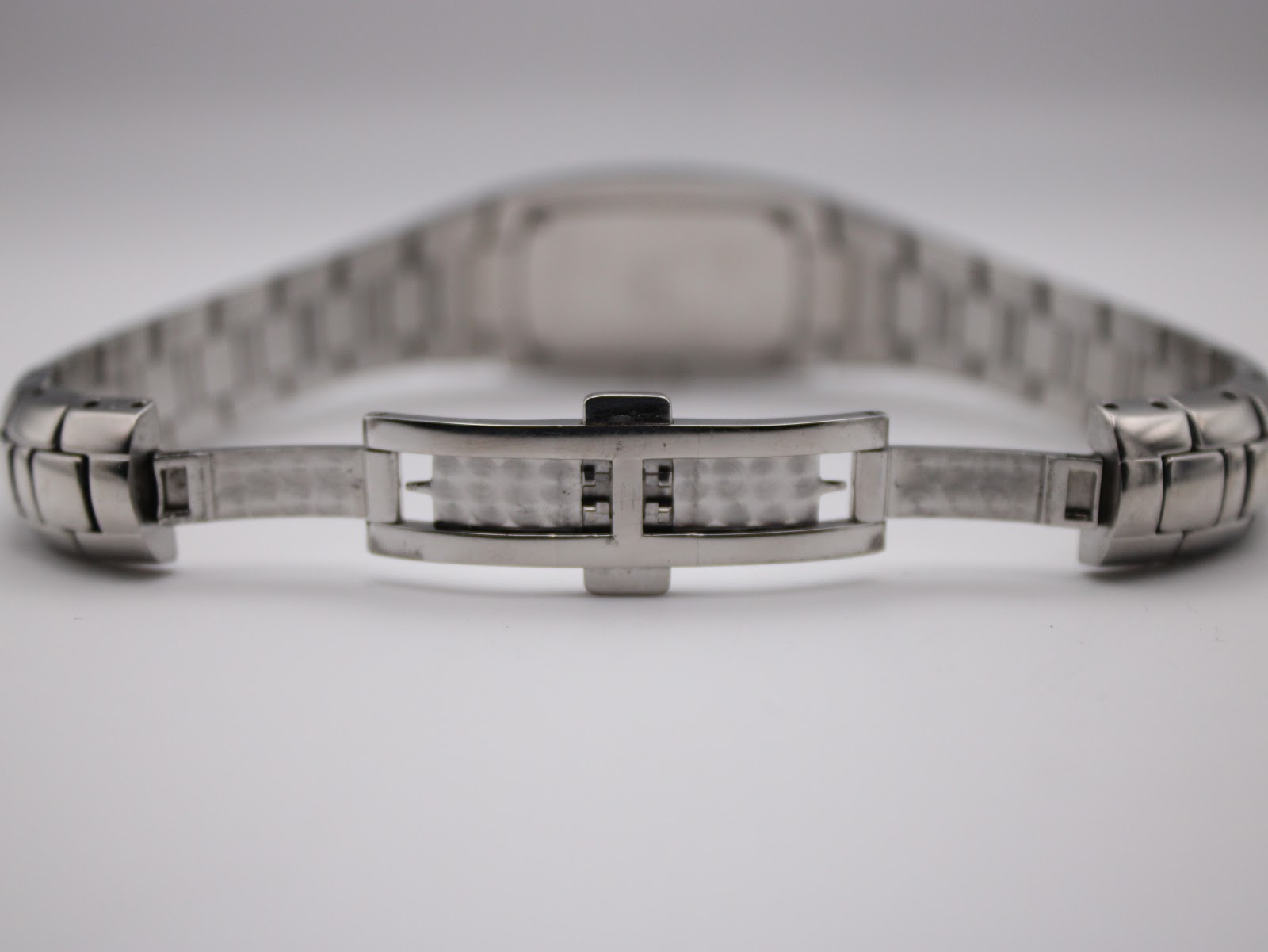 Rear view of the open stainless steel butterfly clasp, showing the inner mechanism of the bracelet.