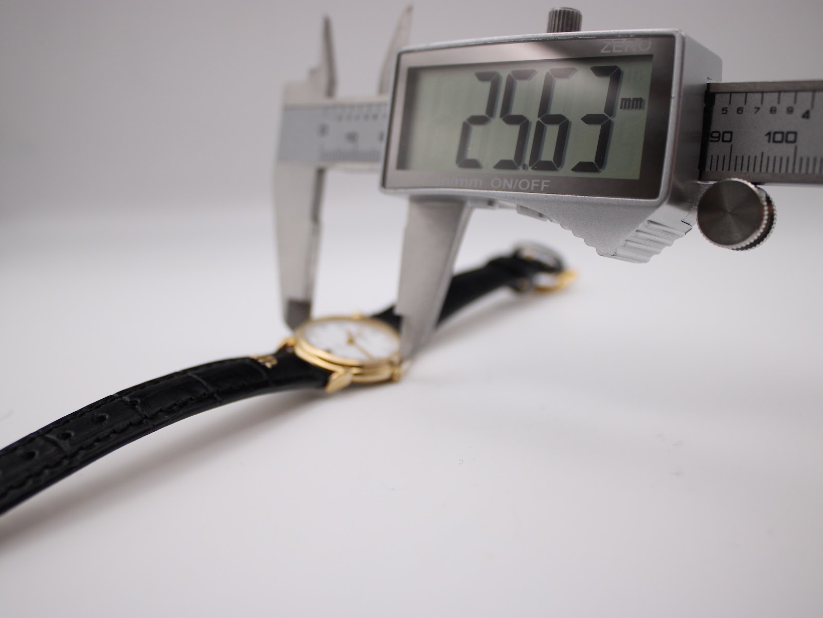 Digital caliper measuring the watch case diameter at 25.63mm, confirming the precise size.