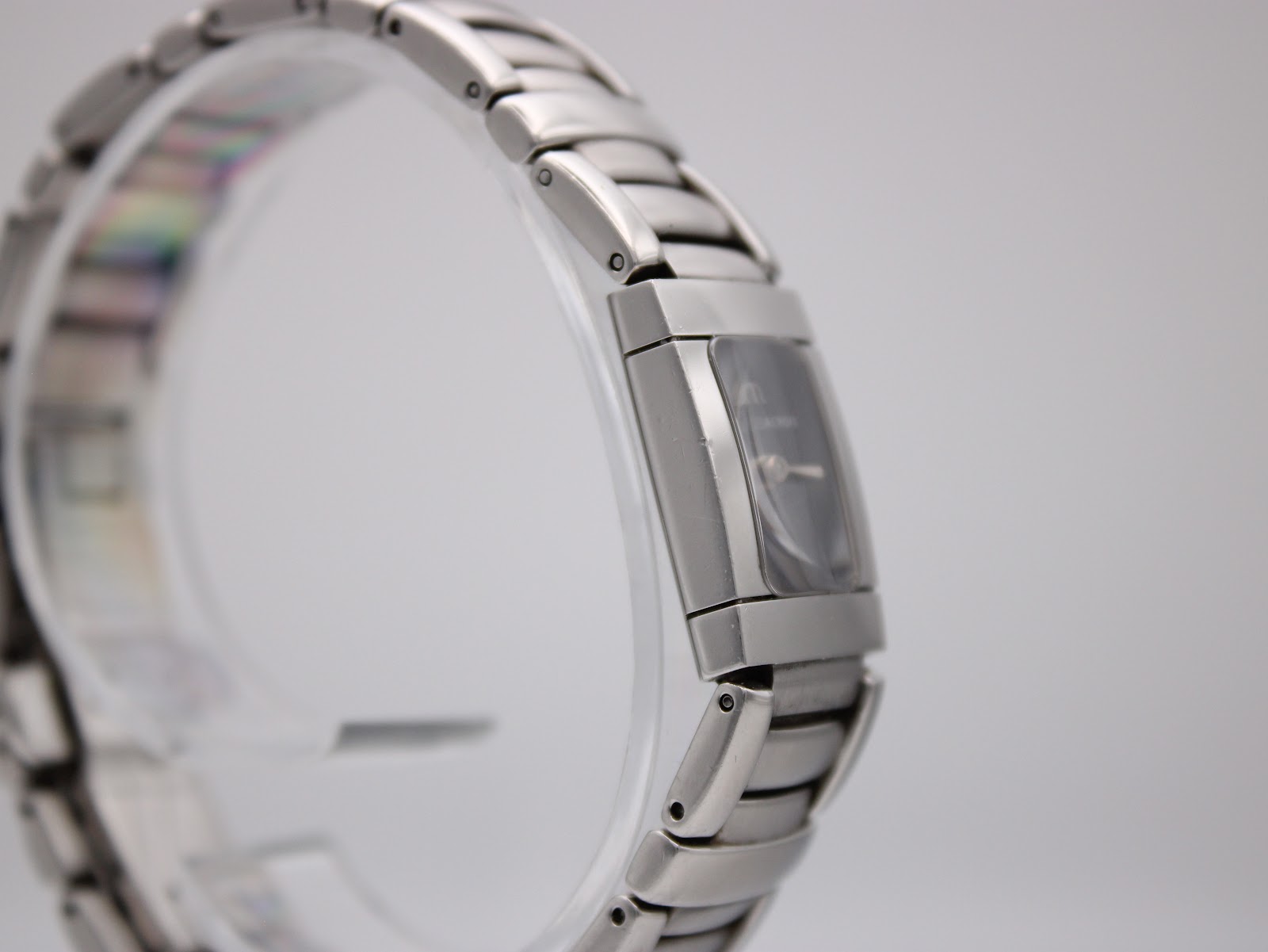 Left side profile view of Maurice Lacroix watch on a display stand, showing the integrated bracelet.