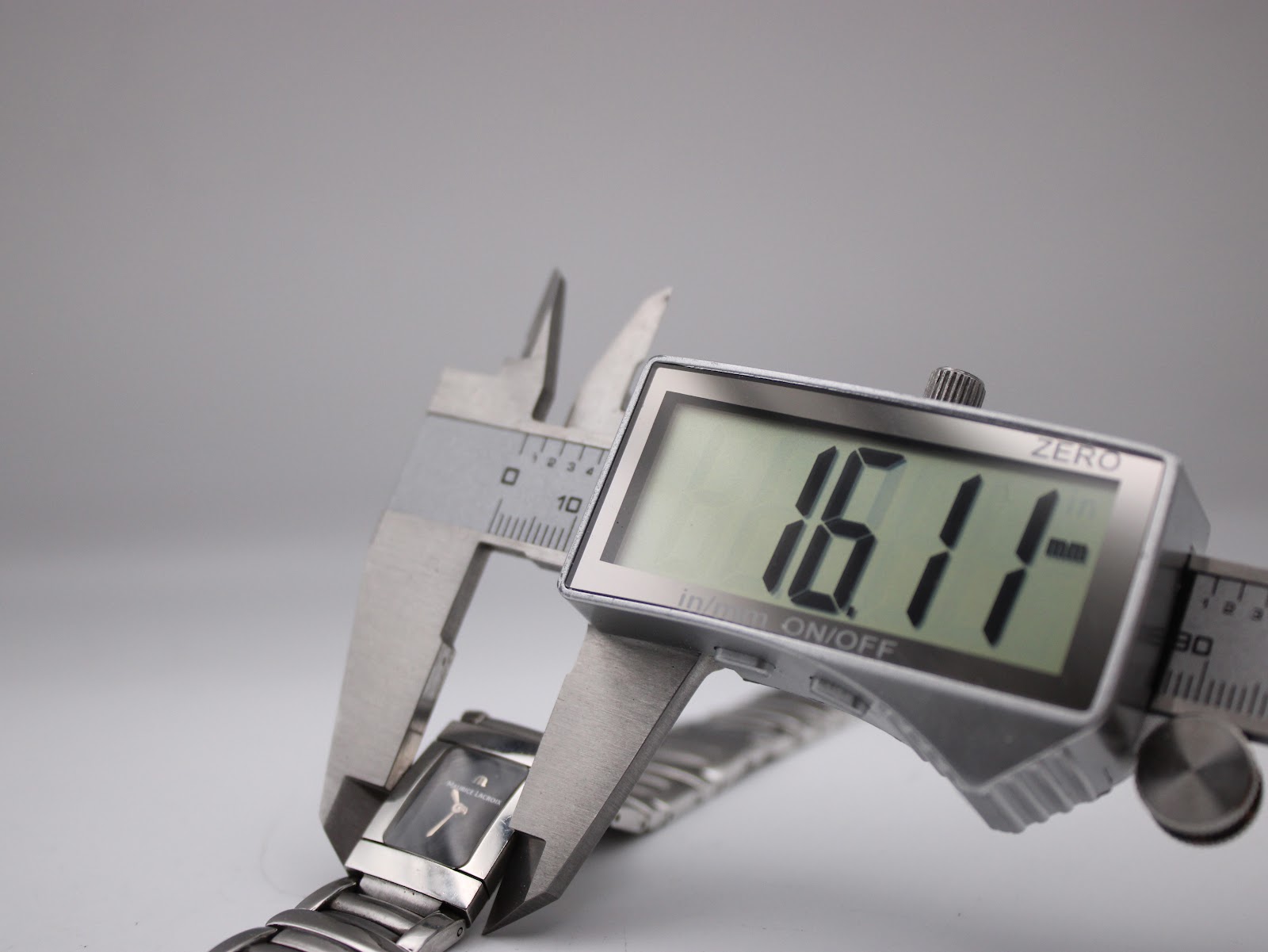 Digital caliper measuring the case width of the watch, displaying 16.11mm.