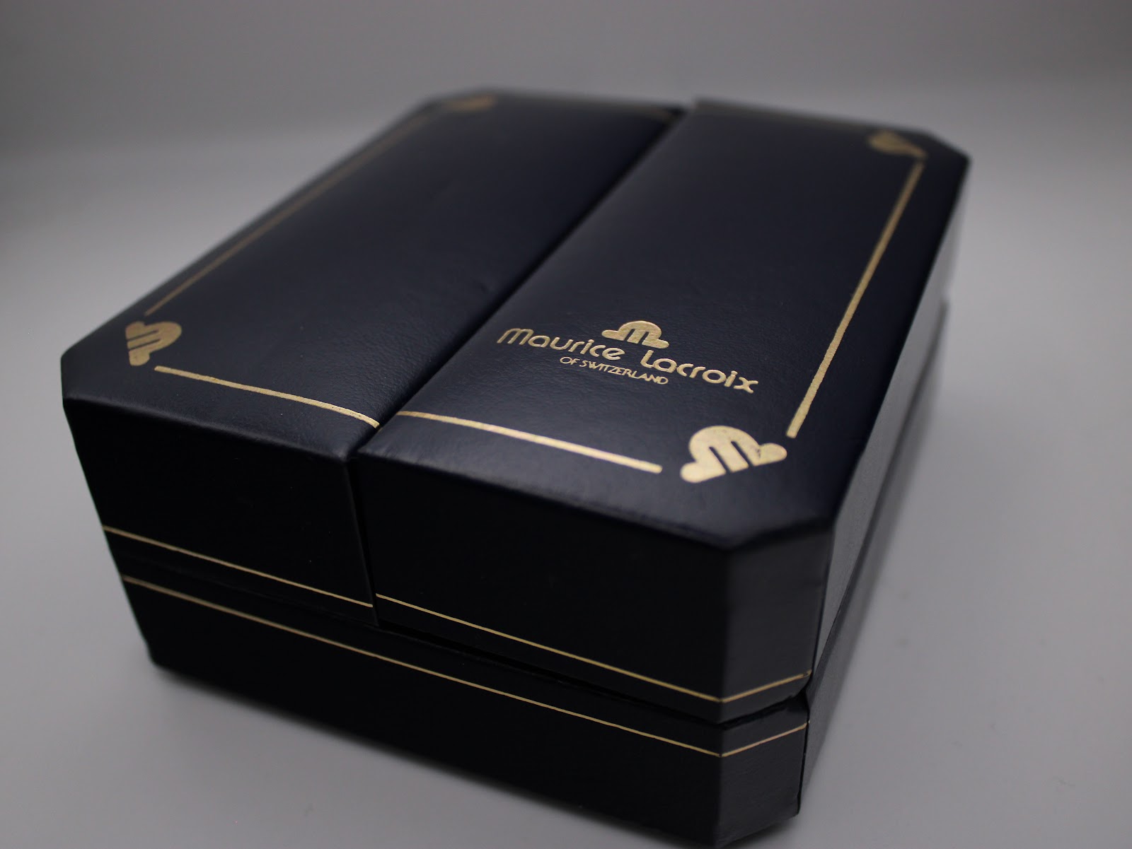 Top view of the closed Maurice Lacroix presentation box, showing the brand logo and gold detailing.
