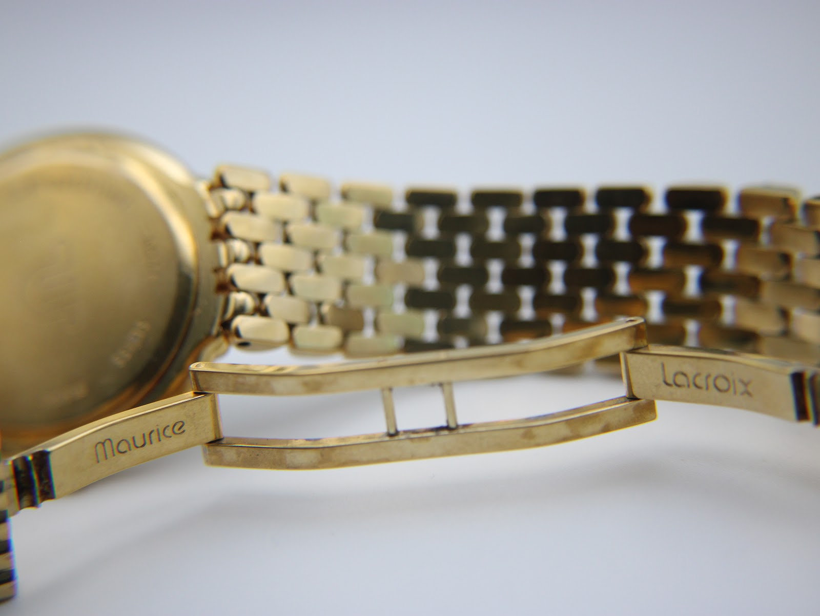 Close-up of the gold electroplated bracelet clasp, showing 'Maurice Lacroix' signature.