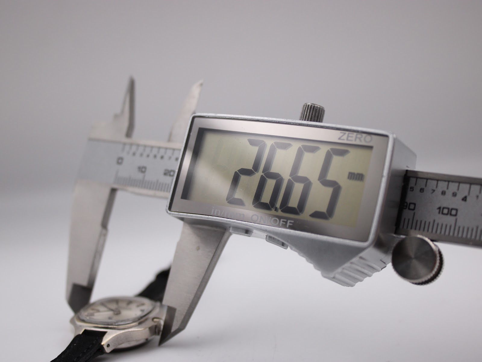 Digital caliper display showing the watch case diameter at 26.65 mm.