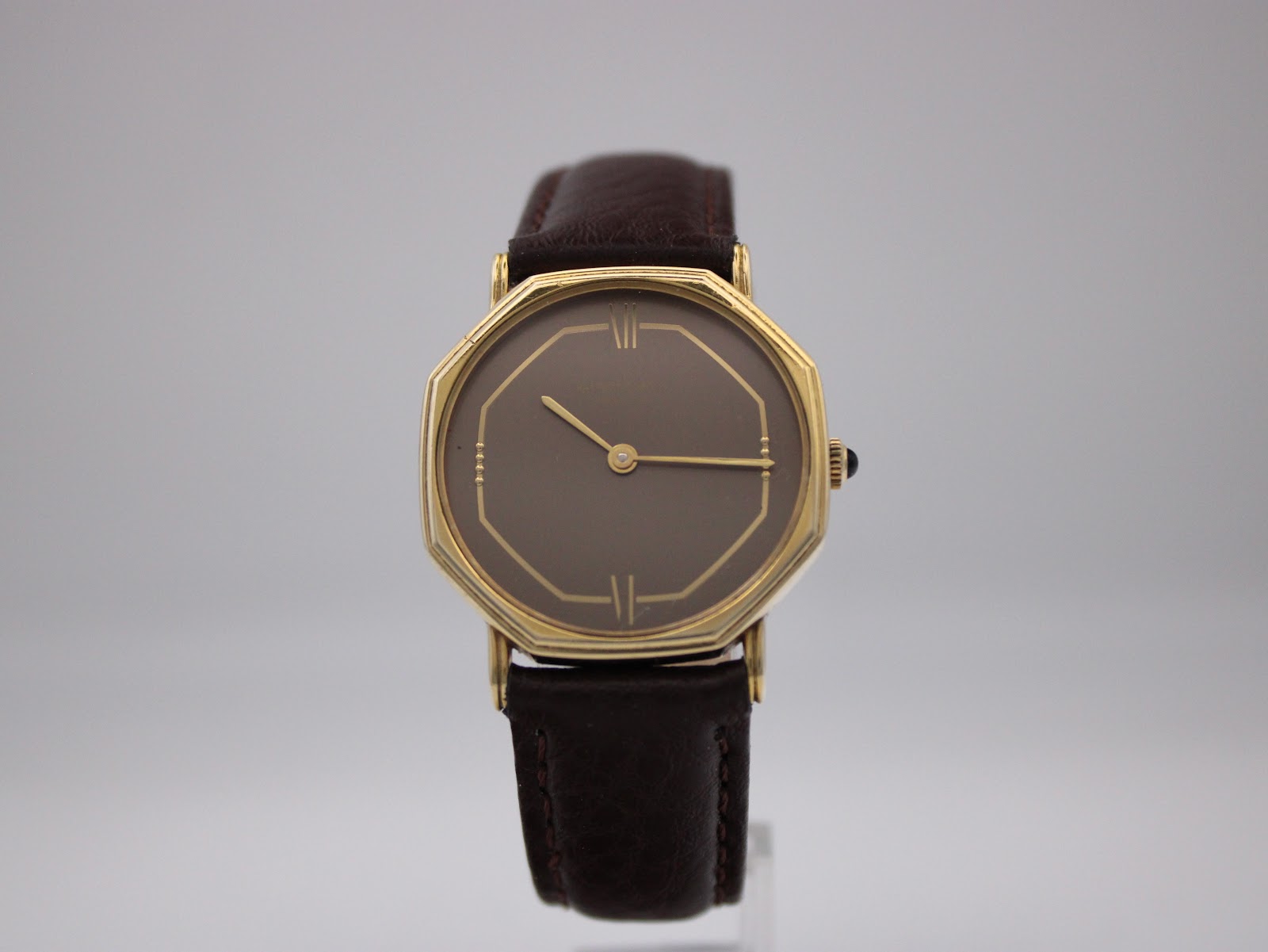 Front view of the Raymond Weil Genève watch, focused on the brown dial, gold case, and new brown leather strap.