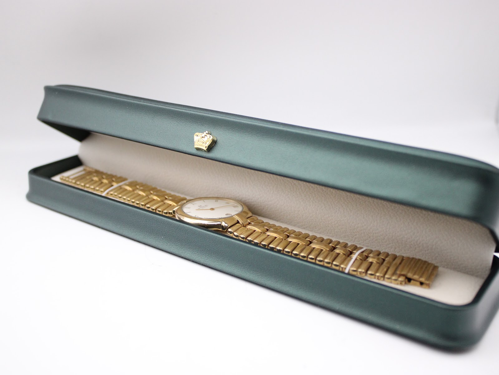 The Raymond Weil gold plated watch presented inside its original dark green presentation box with a cream interior.