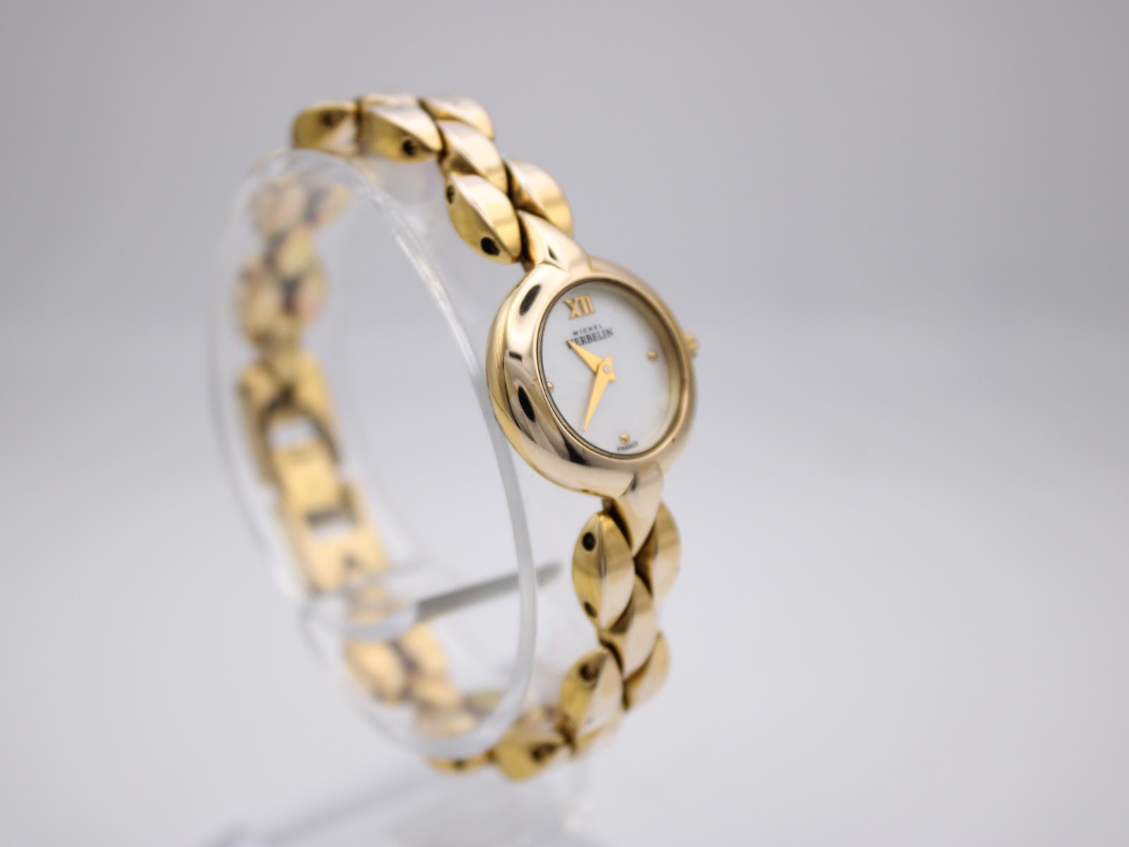 Angled view of Michel Herbelin ladies watch from the left, highlighting the elegant design of the gold-plated integrated bracelet and round case.