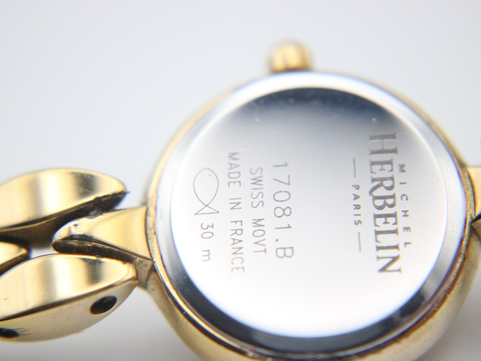 Close-up view of the polished stainless steel case back of the Michel Herbelin watch, showing model reference 17081.B, 'Swiss Movt', 'Made in France', and '30 m' water resistance.