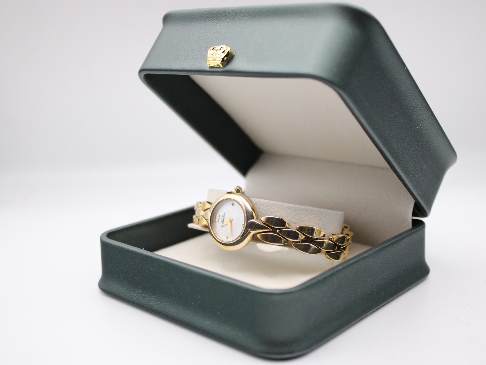 Michel Herbelin ladies watch displayed inside a dark green watch box with a gold crown detail on the lid, showcasing the watch and bracelet.