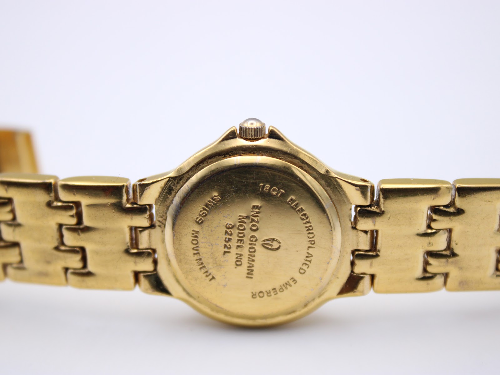 Close-up of the watch case back showing "18ct ELECTROPLATED", "EMPEROR", "ENZO GIOVANNI", "MODEL NO. 9252L", and "SWISS MOVEMENT".