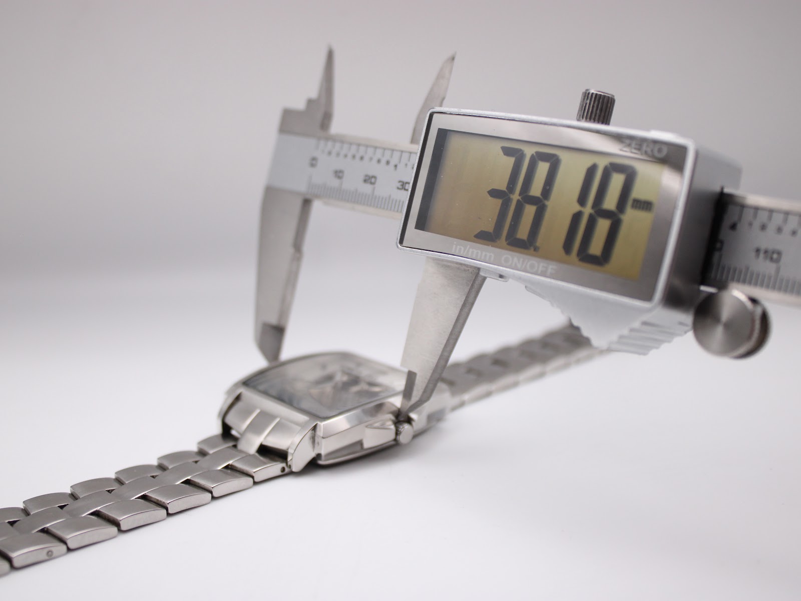 Digital caliper measuring the case diameter of the watch, displaying 38.18mm.